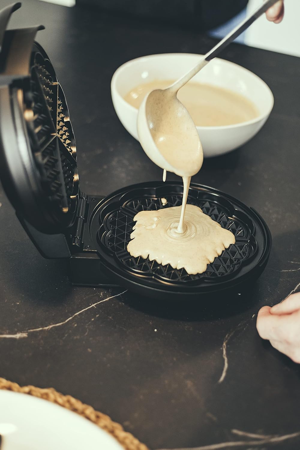 Person pouring waffle batter into the Severin WA 2103 Waffle Maker