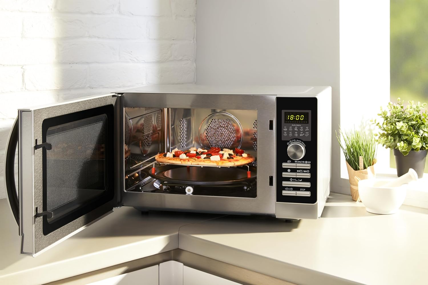 Sharp R843INW microwave with a pizza cooking inside