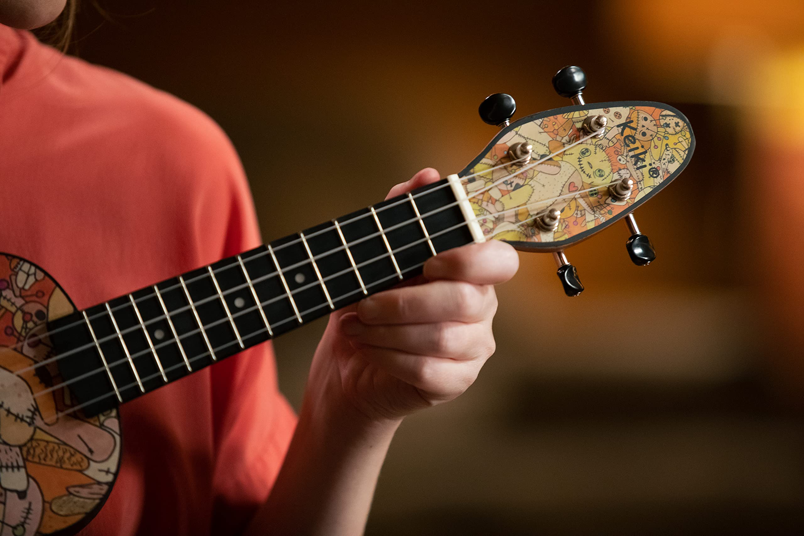 Ortega Guitars Ukelele Soprano - Keiki K2 con diseño de Voodoo Puppet - incluye afinador, 5 puas de grosor medio y funda estilo bolsa con cuerdas con logo Keiki - madera de Kauri, K2-VP