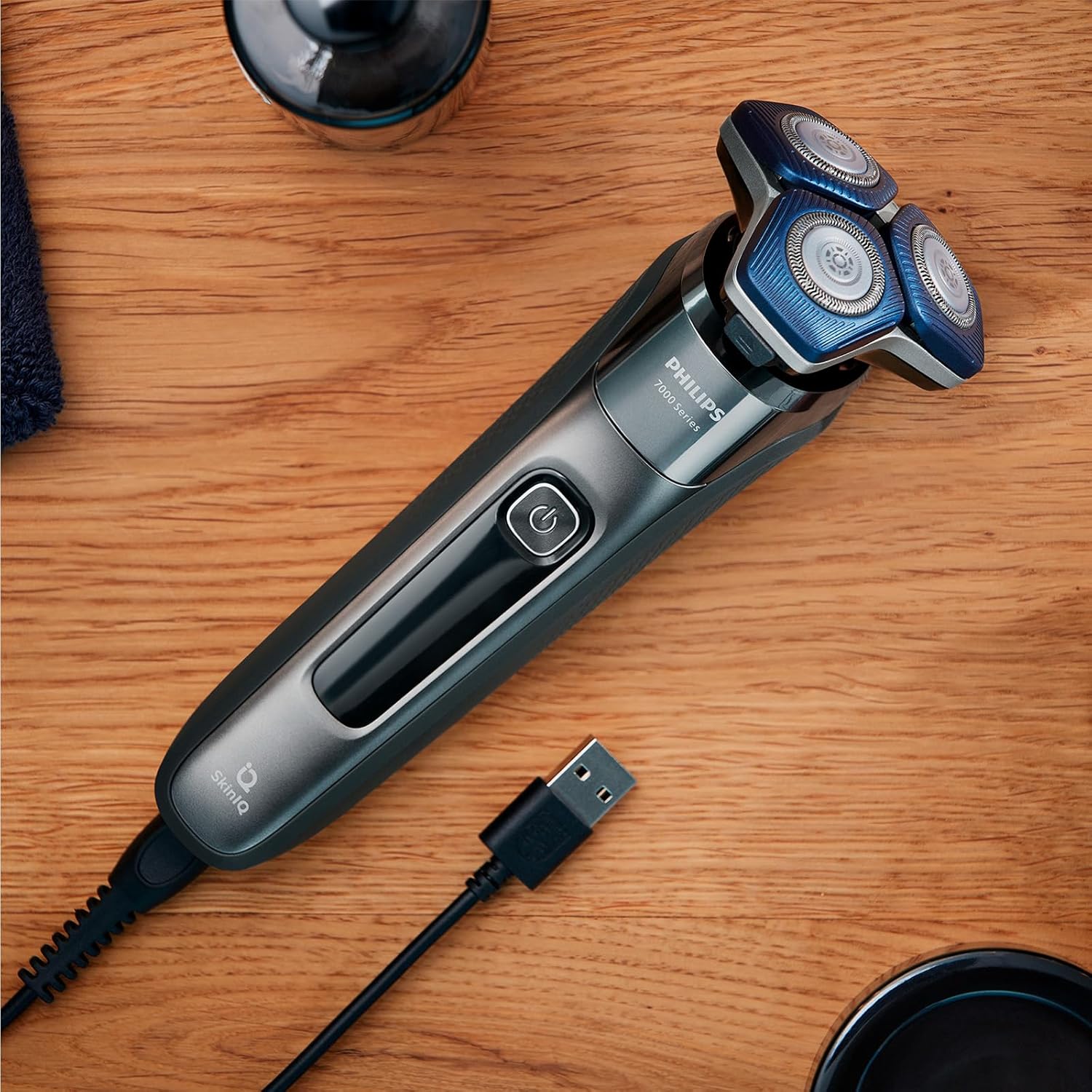 Philips Series 7000 Shaver on a wooden surface with its USB charging cable connected