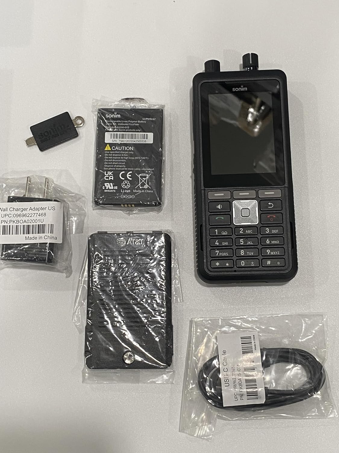 Contents of Sonim XP5 Plus package including phone, battery, power adapter, and USB-C cable.