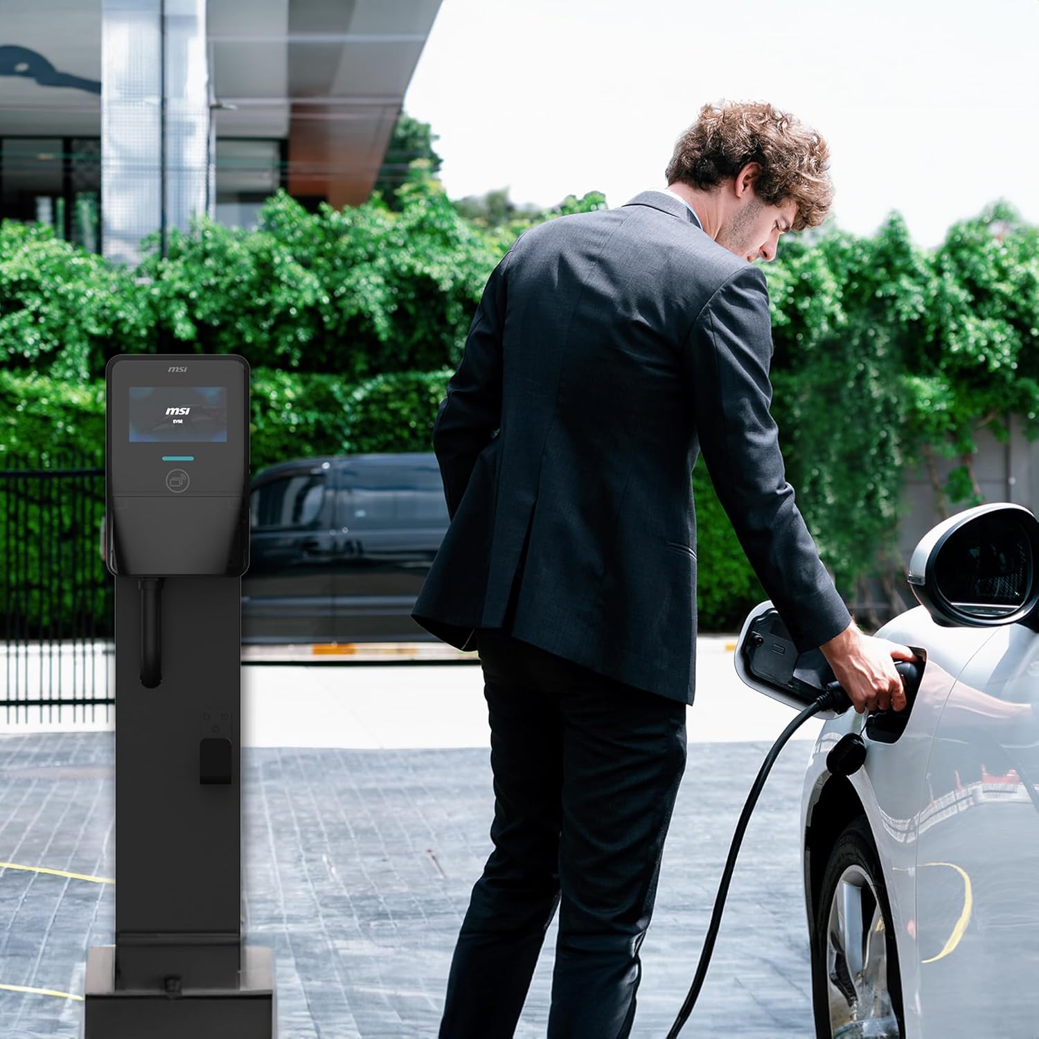 Man plugging in EV charger to car