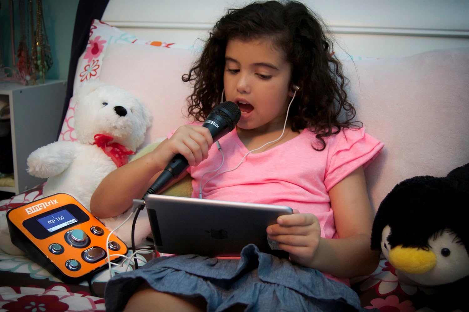 Young girl using Singtrix karaoke system with headphones and tablet.