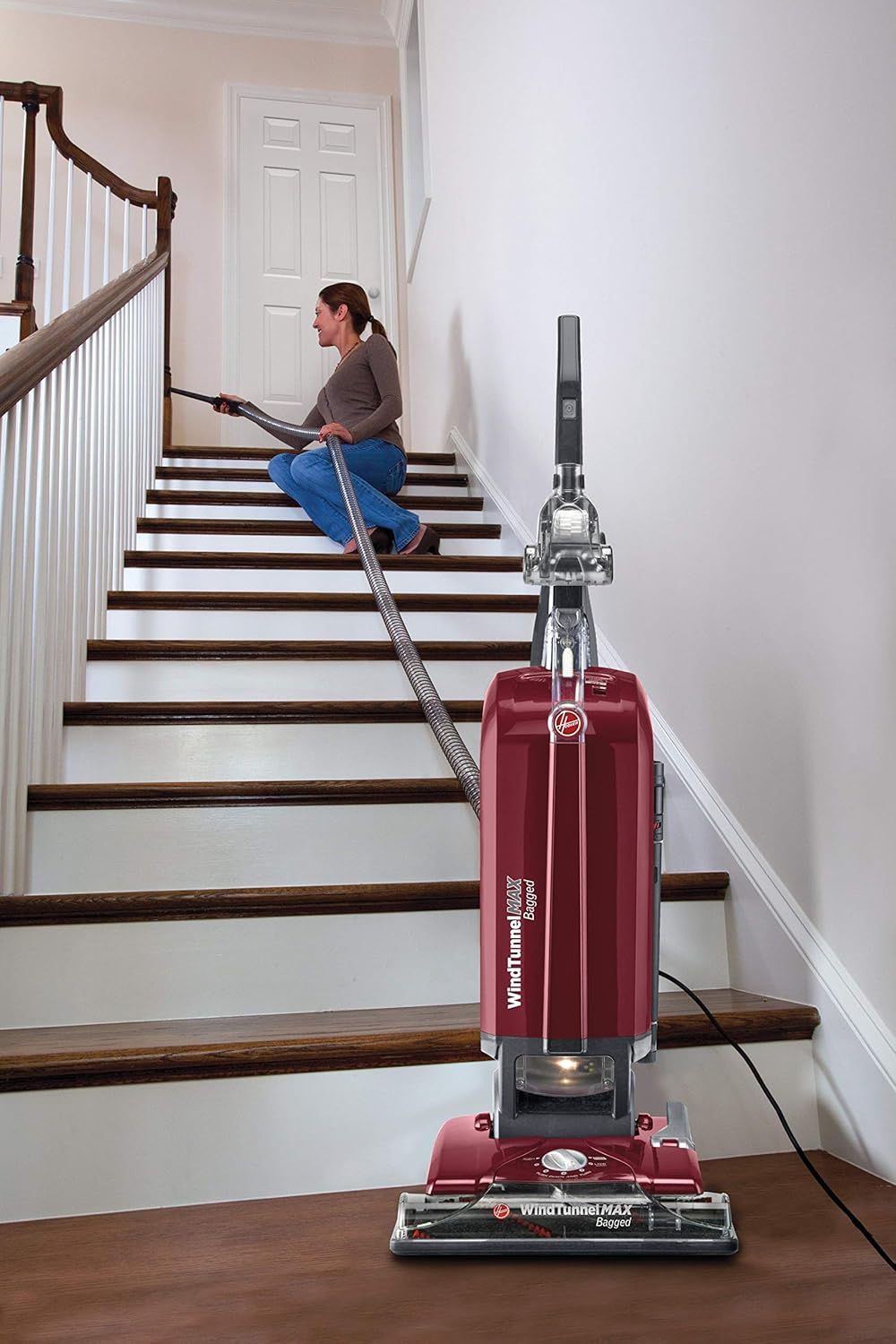 Person using hose attachment to vacuum stairs