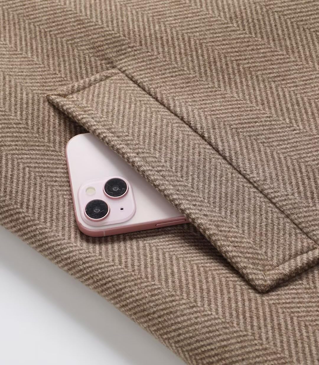 A close-up view of a phone placed in a coat pocket.