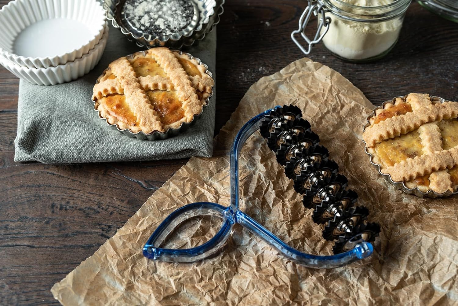 MARCATO Bike Pasta Cutter next to small tarts on a wooden surface