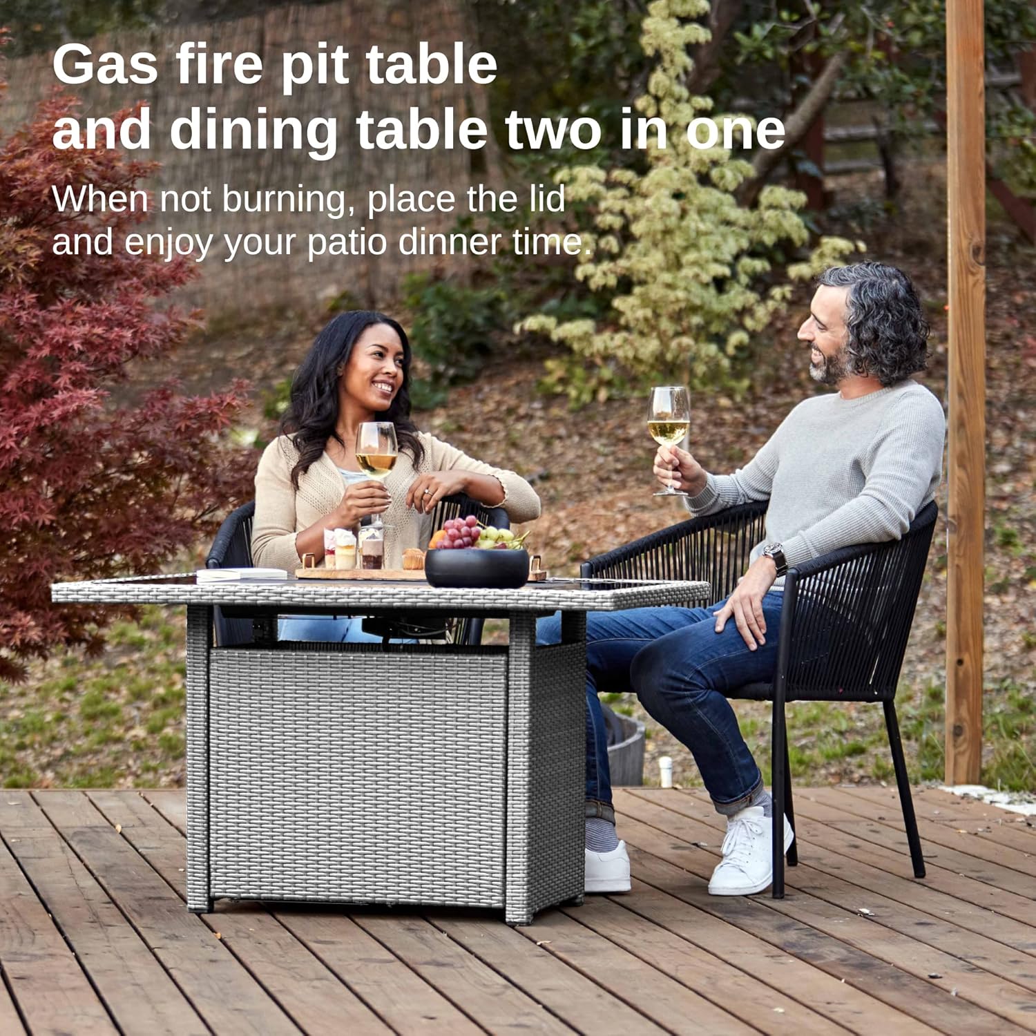 The fire pit table with the lid on, functioning as a dining table, with two people enjoying a meal.