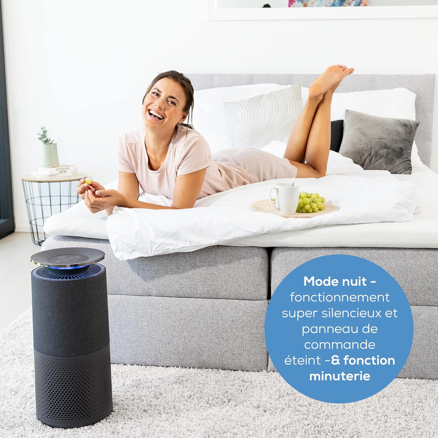 Beurer LR 401 Air Purifier operating in a bedroom during night mode, with a user relaxing nearby, emphasizing its quiet operation.