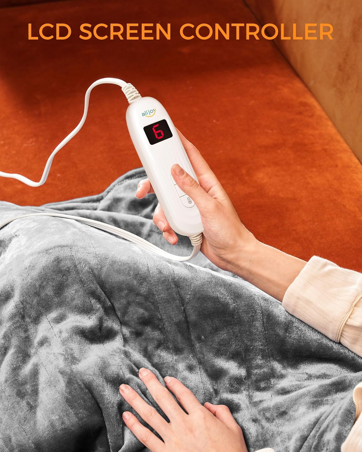 Close-up of a hand holding the ALLJOY Heated Blanket controller, showing the digital display and control buttons.