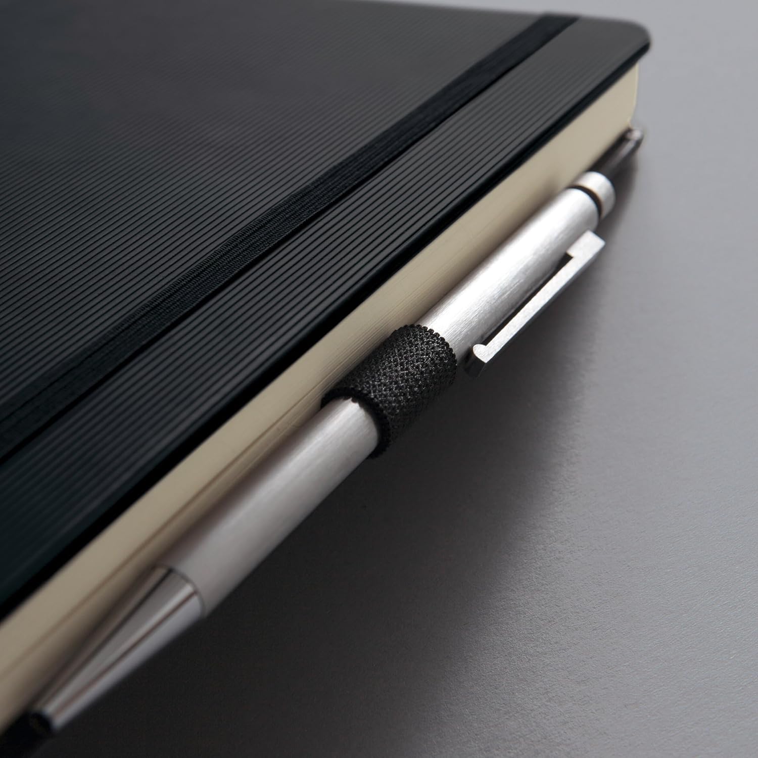 Close-up of the Sigel notebook's elastic pen loop holding a silver pen