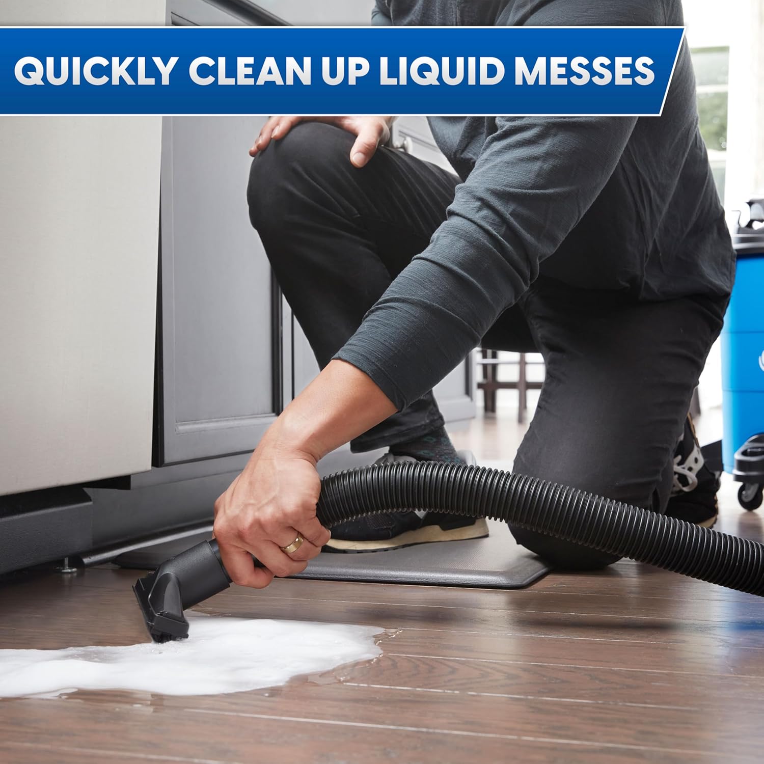 Person using Vacmaster wet/dry vacuum to clean up a liquid spill on a hard floor.