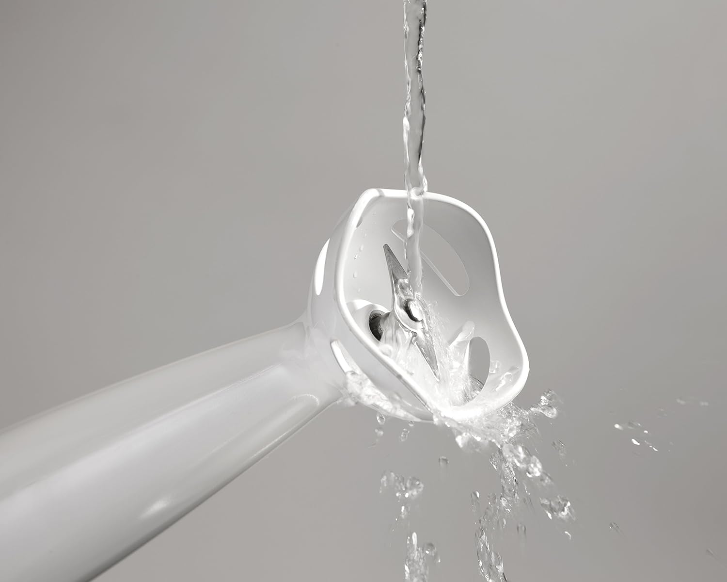 Detachable blending stick being rinsed under water