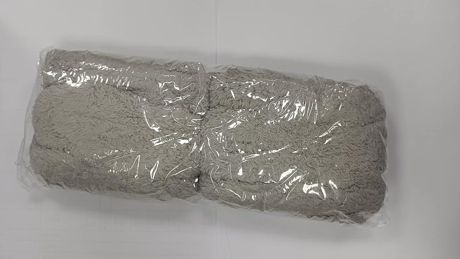 Twelve grey microfiber cleaning pads individually wrapped in clear plastic packaging.