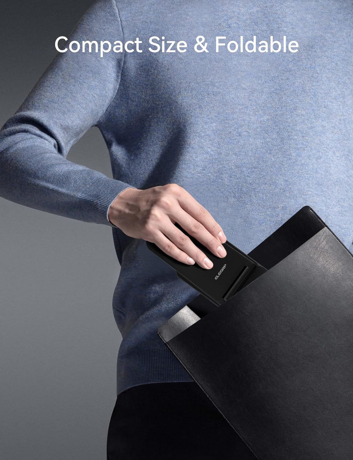 A hand placing the folded ELEGRP Wireless Charging Station into a bag, demonstrating its compact size for travel