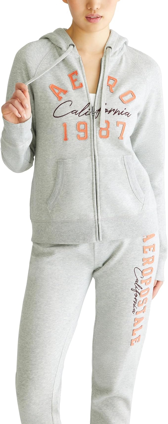 Modelo vestindo conjunto de moletom cinza Aeropostale com capuz e zíper, destaque para a estampa frontal