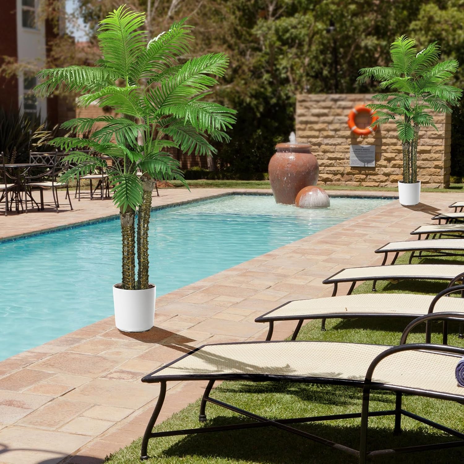 Artificial palm tree placed in a living room next to a sofa