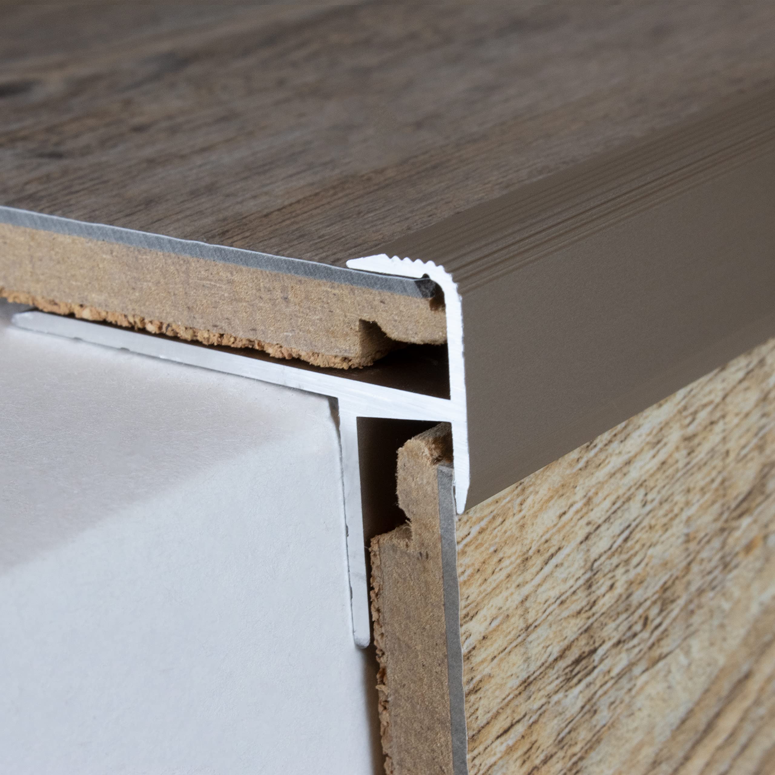 PVC traprenovatie in donker beton look met edelstaal trapneusprofiel