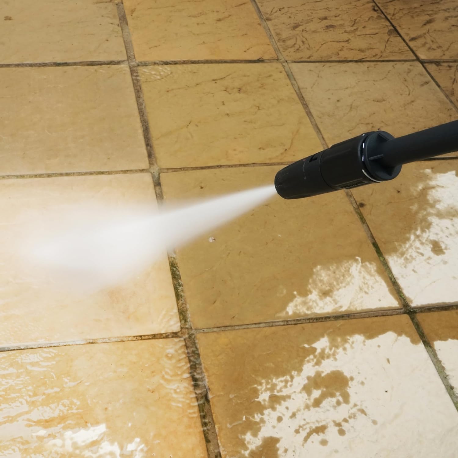 Pressure washing a dirty tiled patio