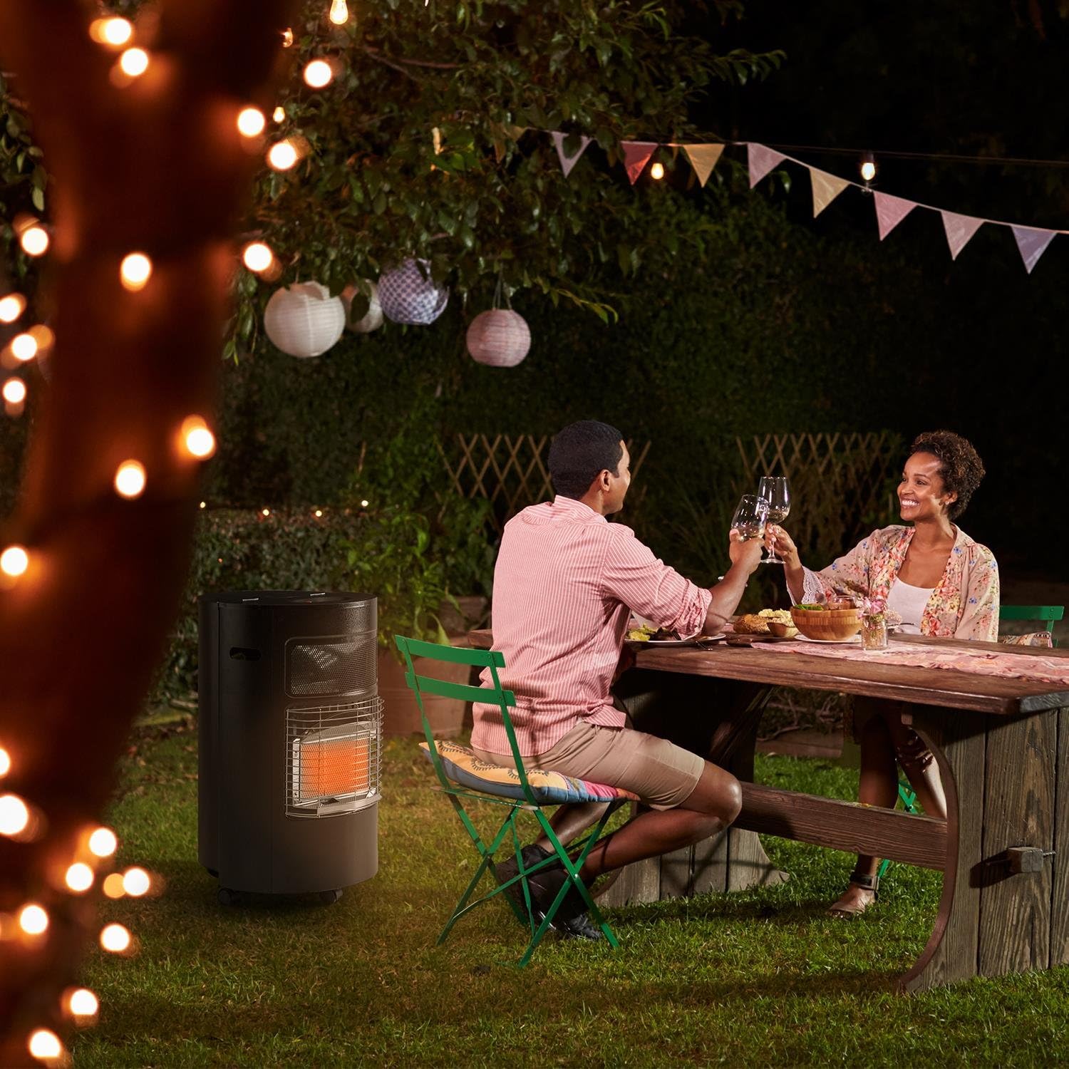 Blumfeldt HHG9-Bonaparte gas heater in an outdoor setting, providing warmth to people sitting at a table.