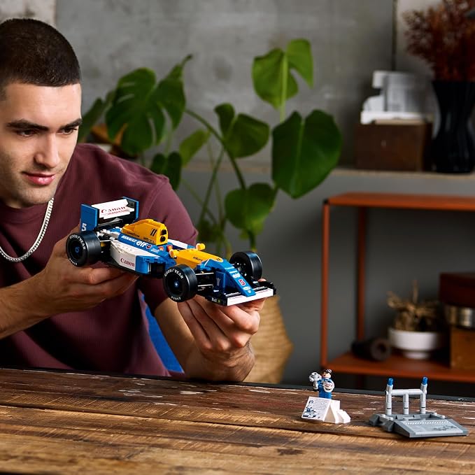 Carro de Formula 1 LEGO Williams FW14B montado em fundo branco com minifigura ao lado