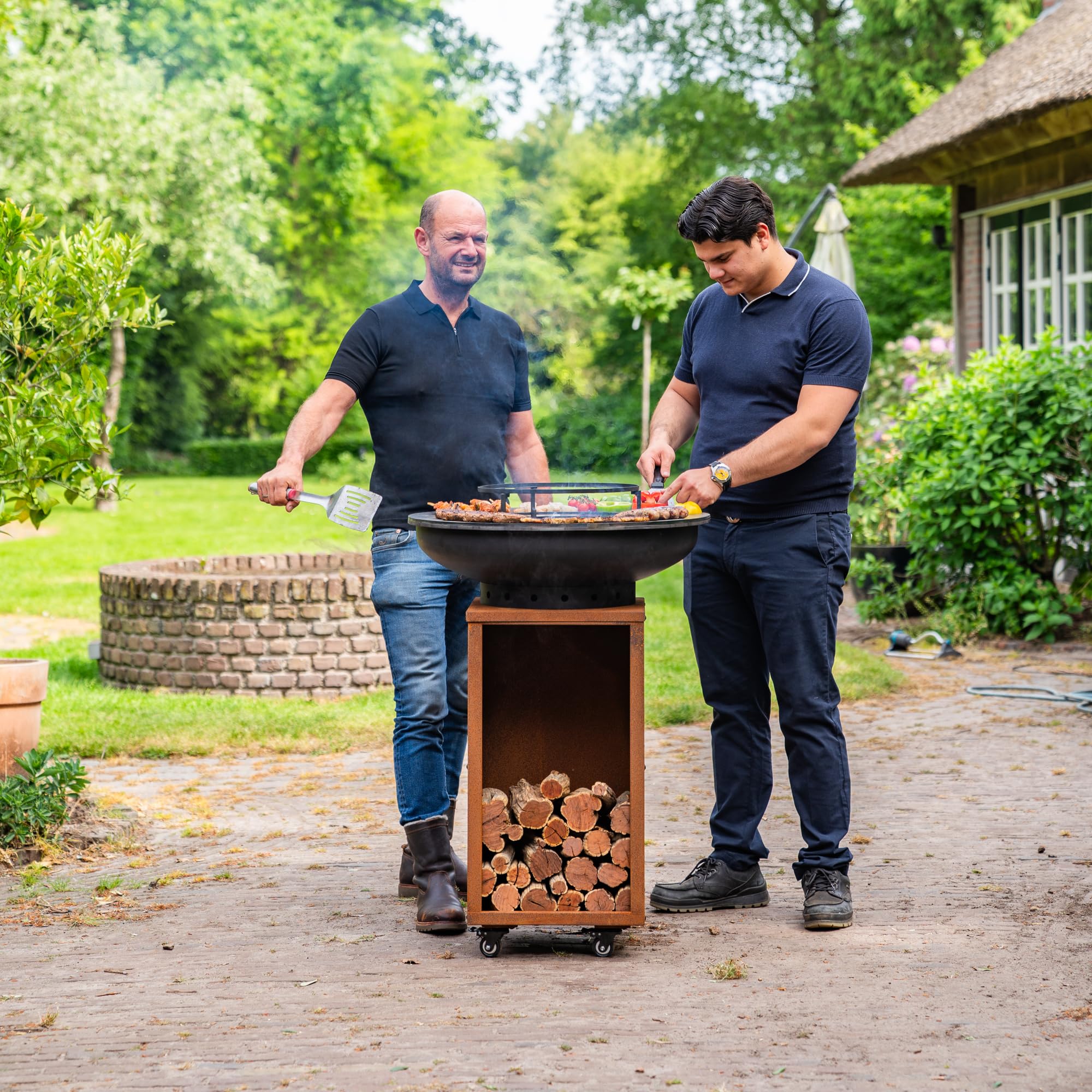 Barbecue Plancha Camarada Blackline Corten Steel 2.0 – con gancio in legno e contenitore in legno Ø 70 cm