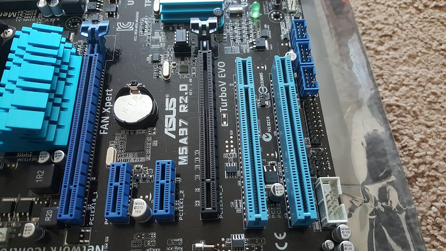 Close-up view of the PCIe and PCI slots on the ASUS M5A97 R2.0 motherboard.