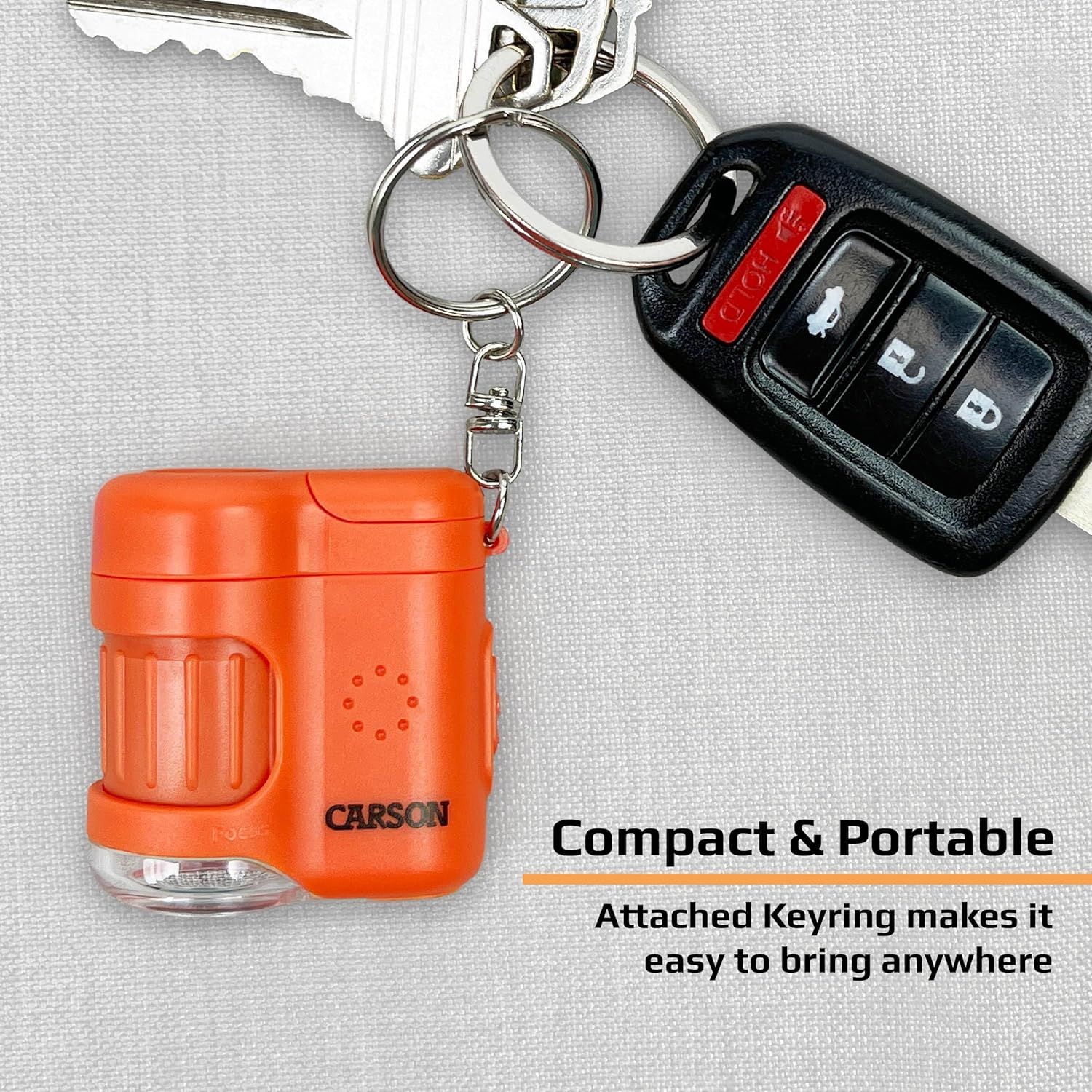 Carson MicroMini 20x Pocket Microscope attached to a keychain with car keys, illustrating its compact and portable design.