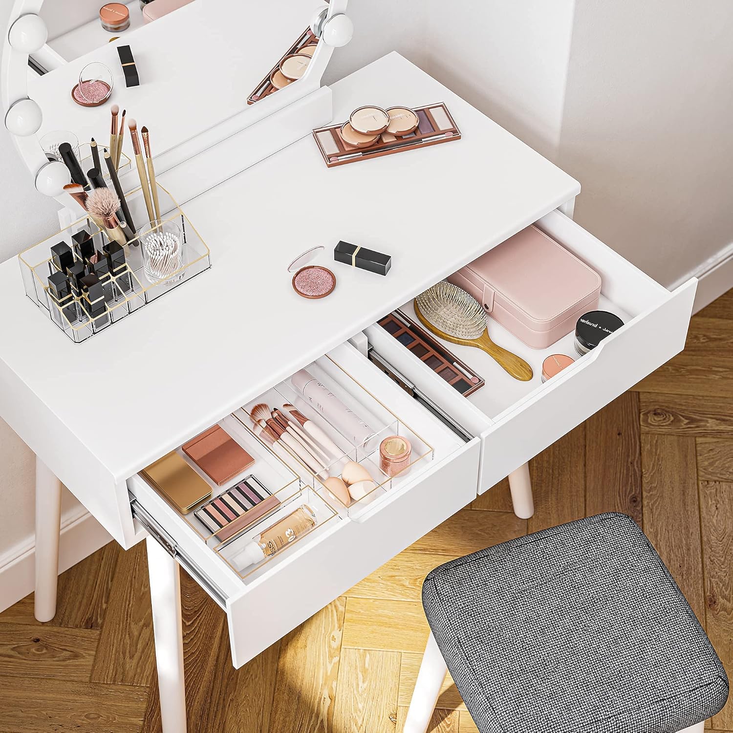 Top-down view of the vanity with drawers open, showing organized makeup and accessories