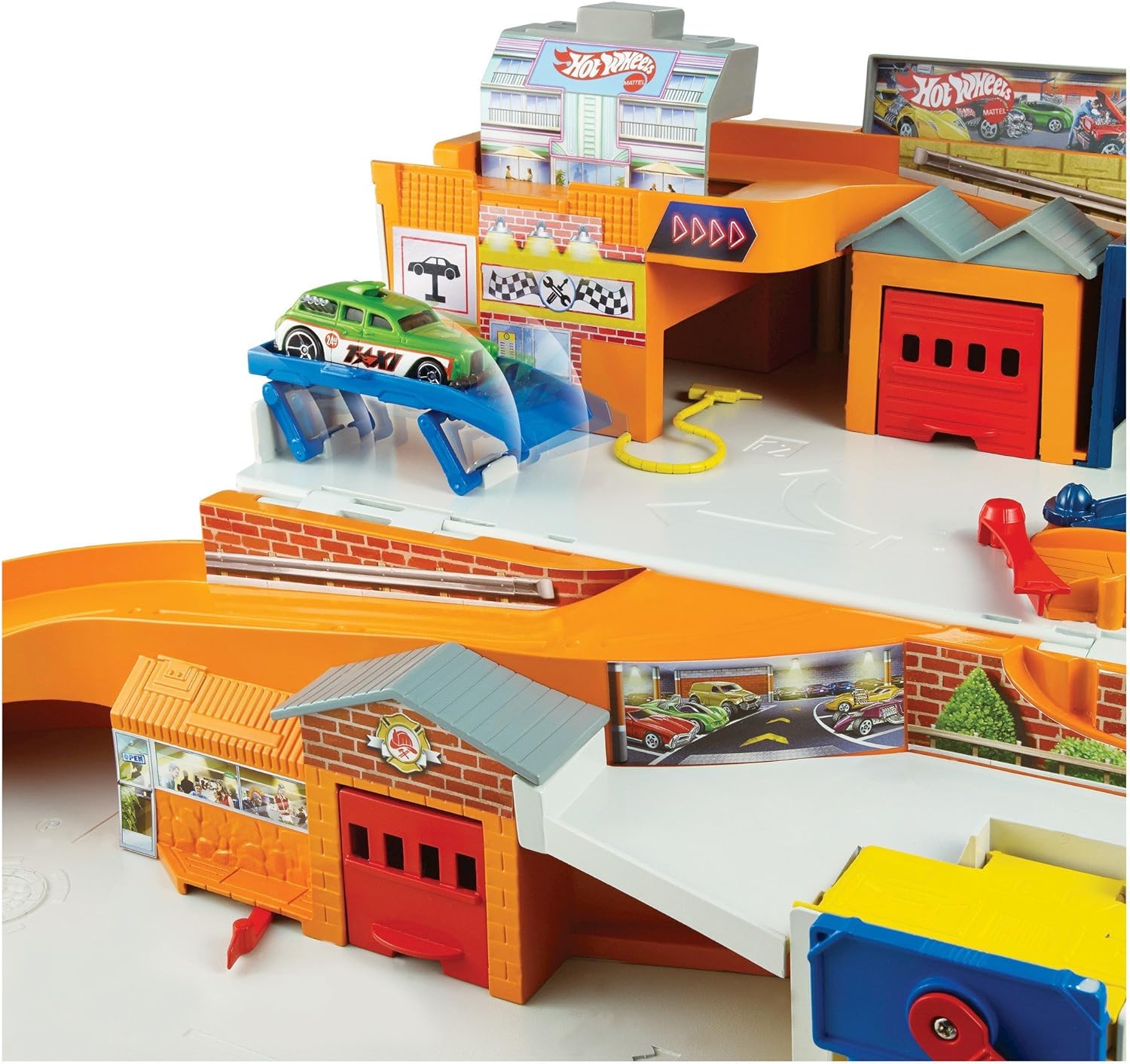 Sebuah close-up view of a green Hot Wheels car on a blue service lift within the playset, demonstrating a service bay feature.