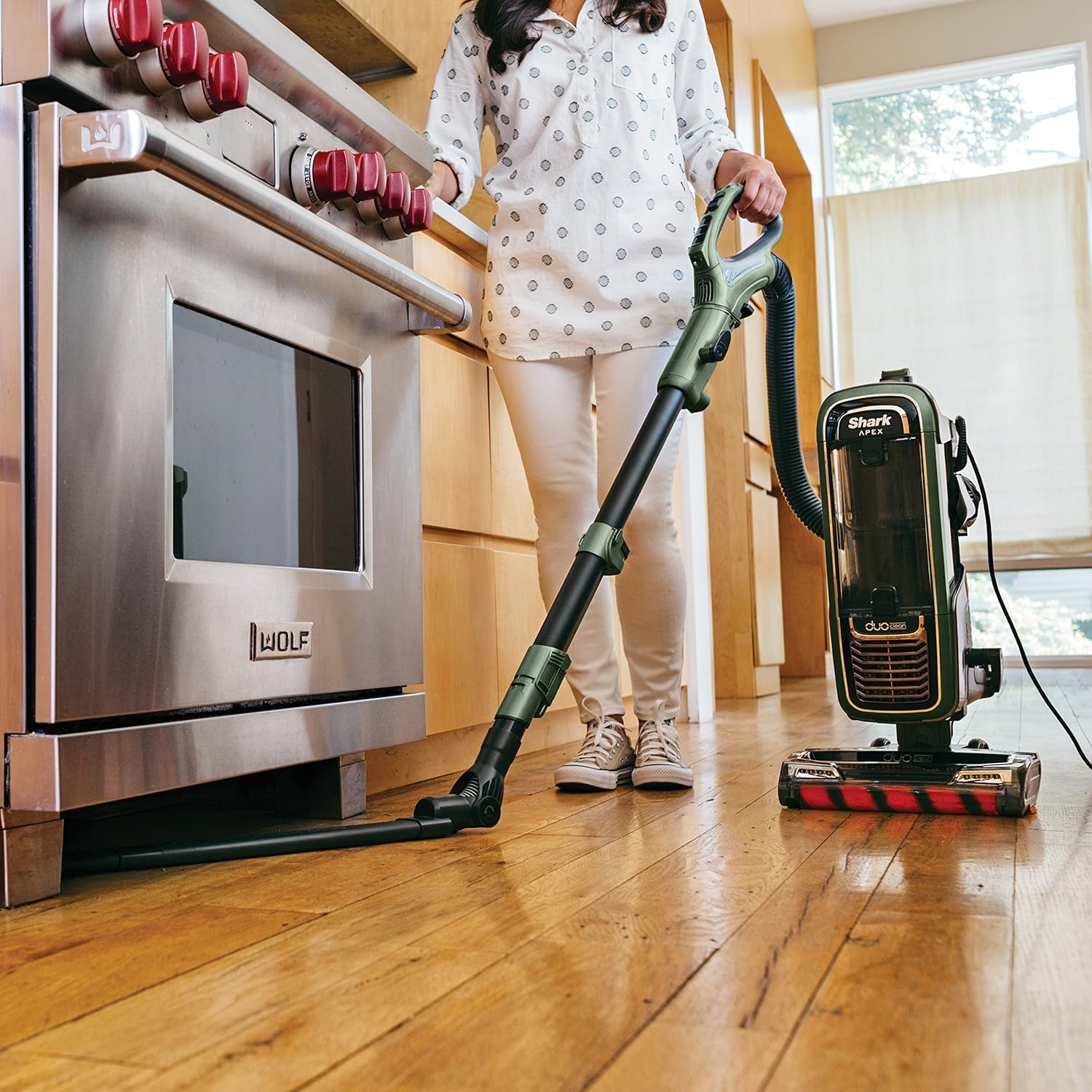 Woman using Shark APEX wand with attachment for high cleaning