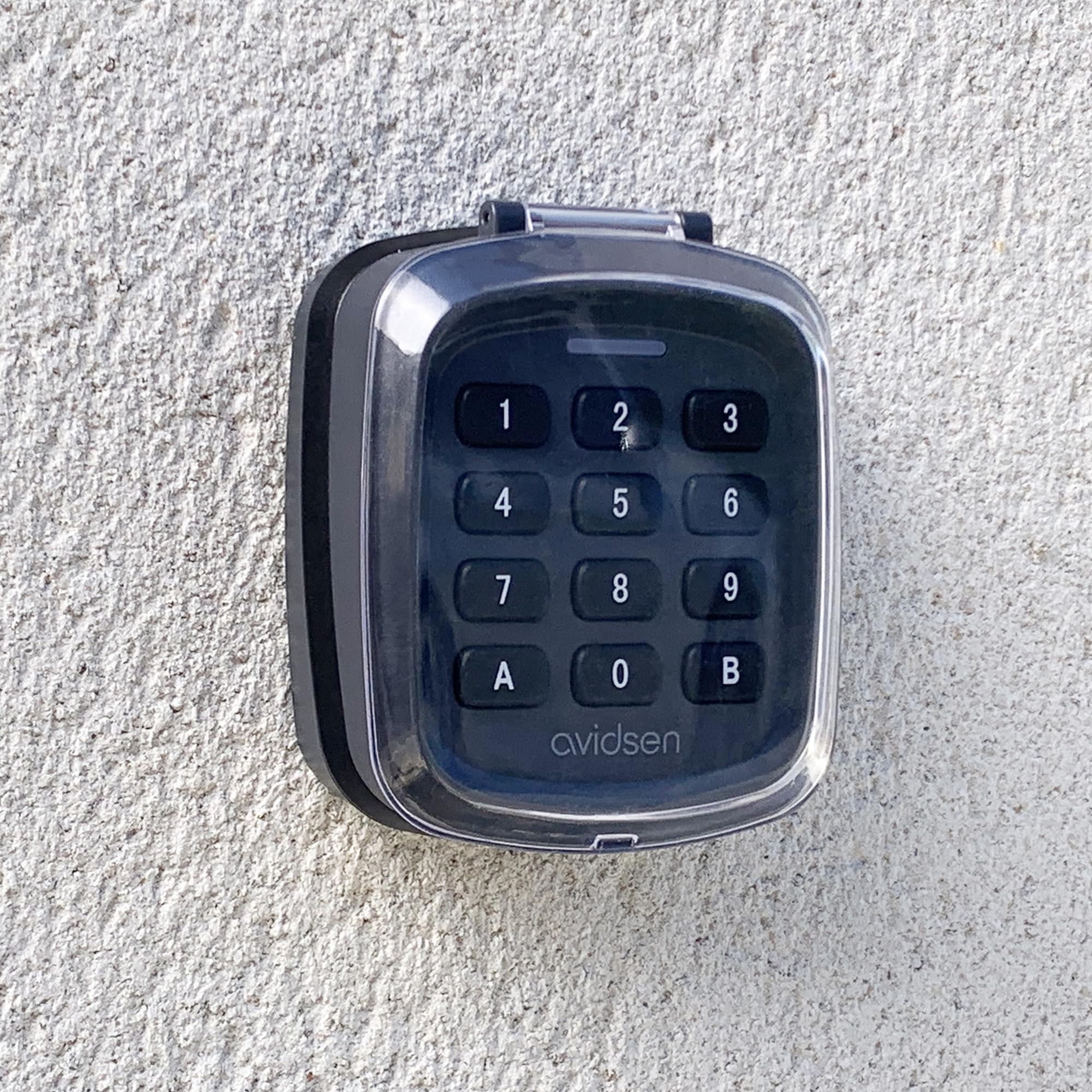 Avidsen Teclado Inalámbrico para Puertas de Garaje y Cancelas con Código | 10 códigos de 4 dígitos, alcance 80 m, 433,92 MHz, IP44, -20 °C a 55 °C, 2 pilas AAA incluidas y apertura total o peatonal.