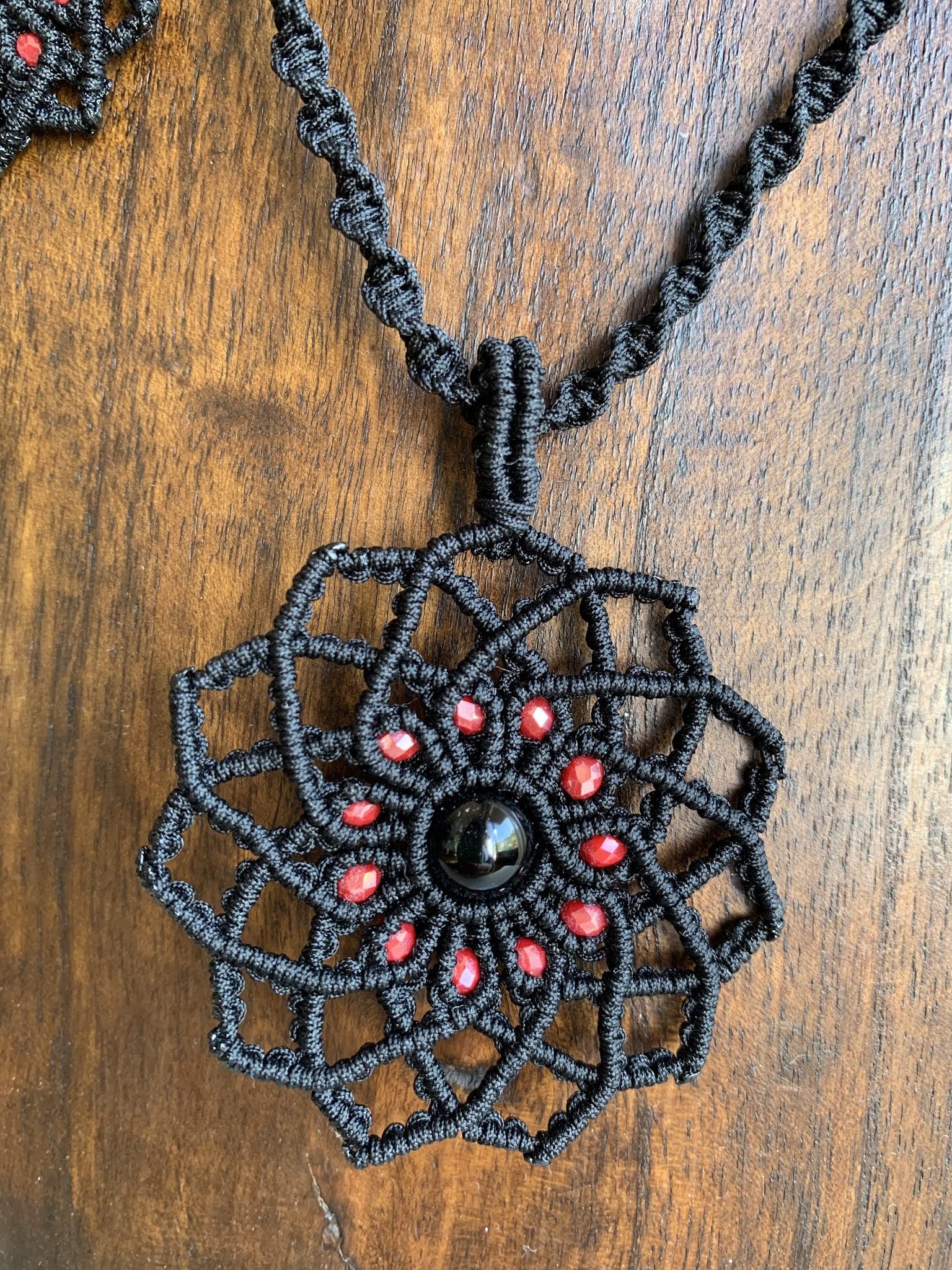 Collar con colgante estrella hecho a mano,negro con cuentas rojas y onix central. Cierre ajustable