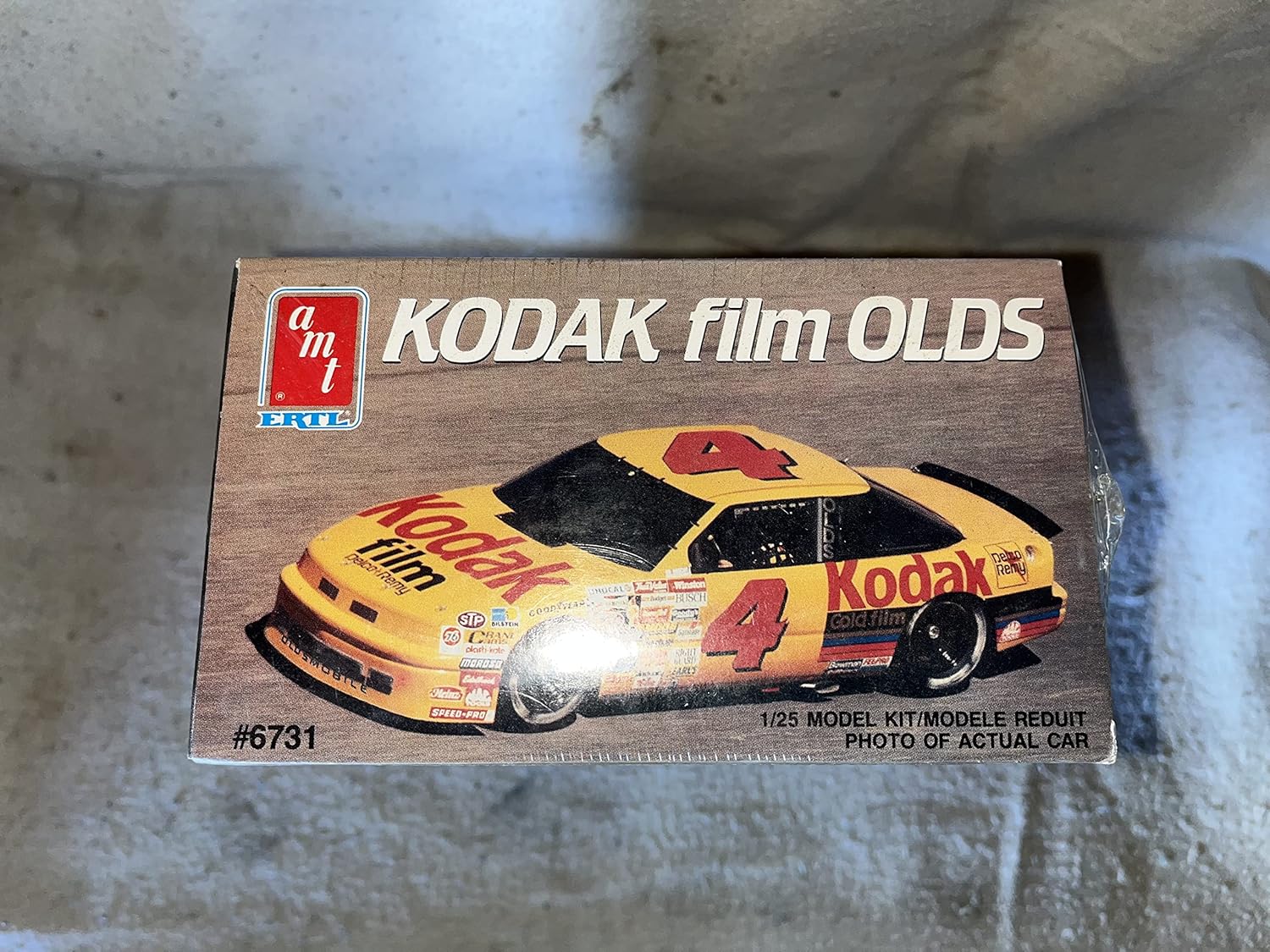 Side view of the AMT #6731 Kodak Film Olds 1/25 Scale Plastic Model Kit box, highlighting the car's profile.