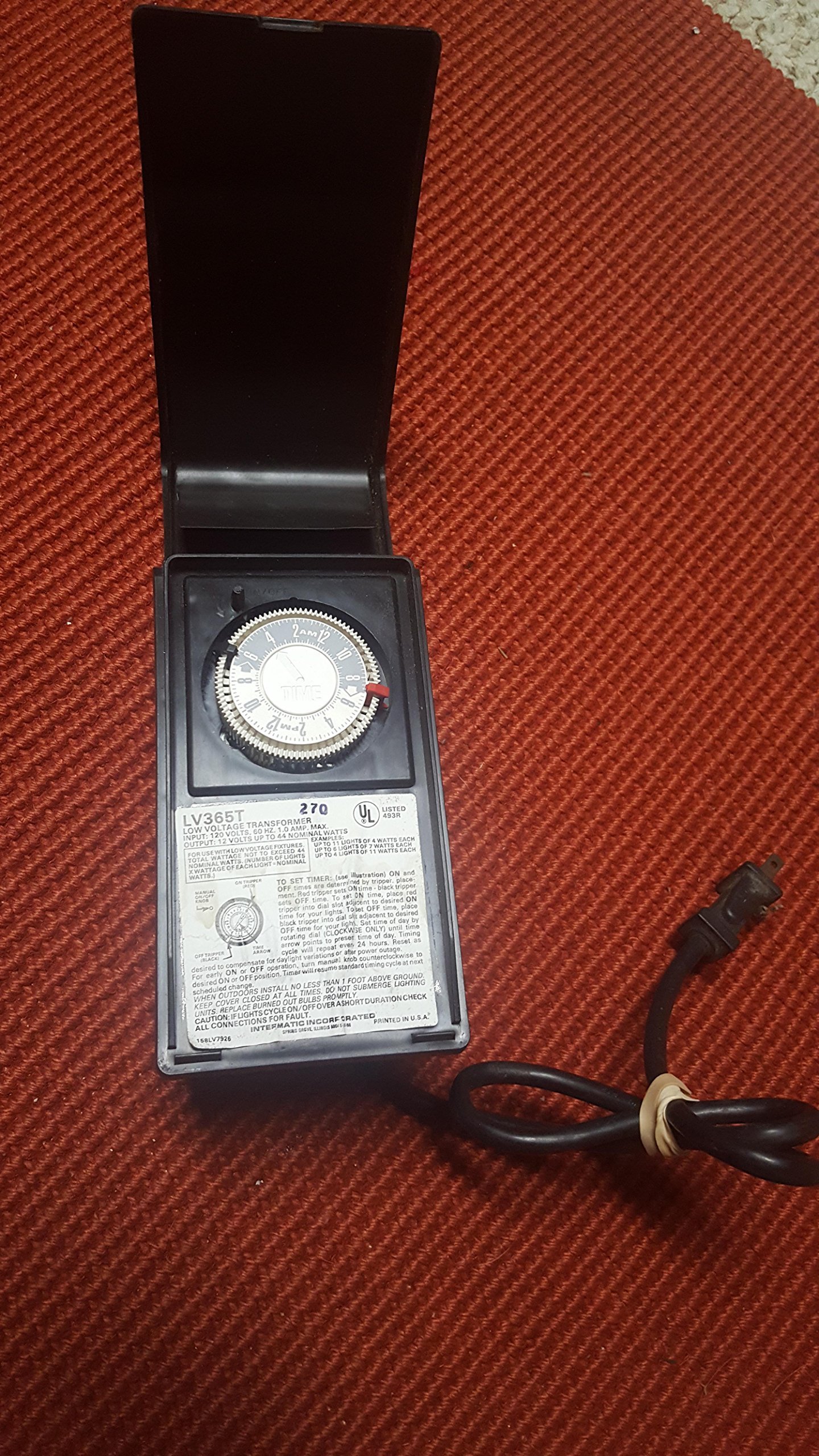 Malibu Intermatic LV365T Low Voltage Lighting Timer Transformer with open cover, showing the timer dial and instruction label.