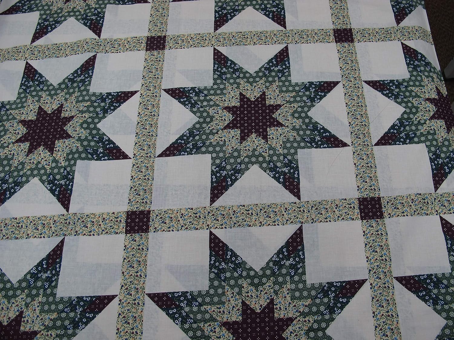 90 Wide Cheater Quilt Top Calico Star Hunter and Burgundy. Fabric is Sold by The Yard and Cut to Order. for Example, Order of 1 Yard (Qty=1) is 36” x 90”. Order of 3 Yards (Qty=3) is 108” x 90”.