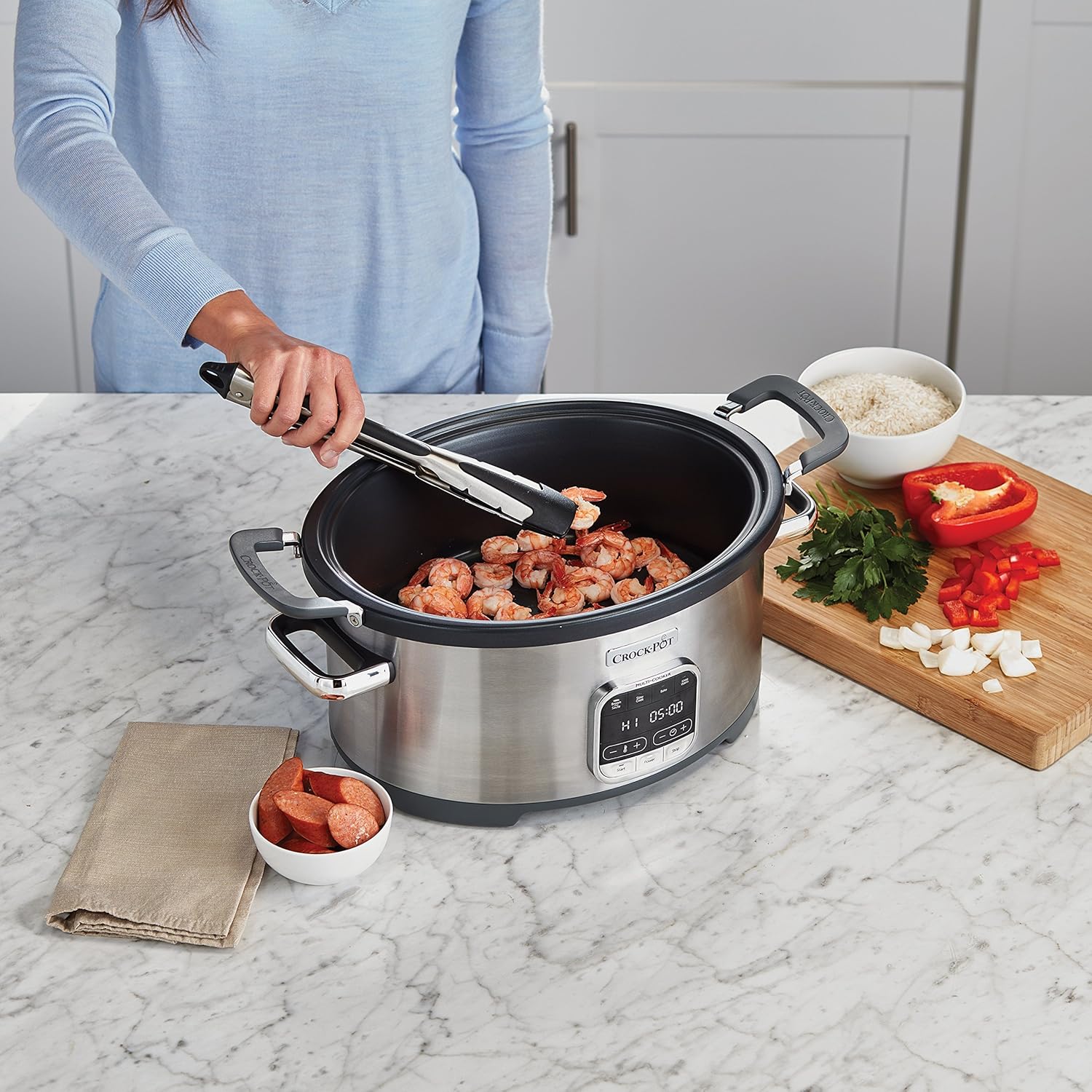 Person browning shrimp in the Crock-Pot Multi-Cooker