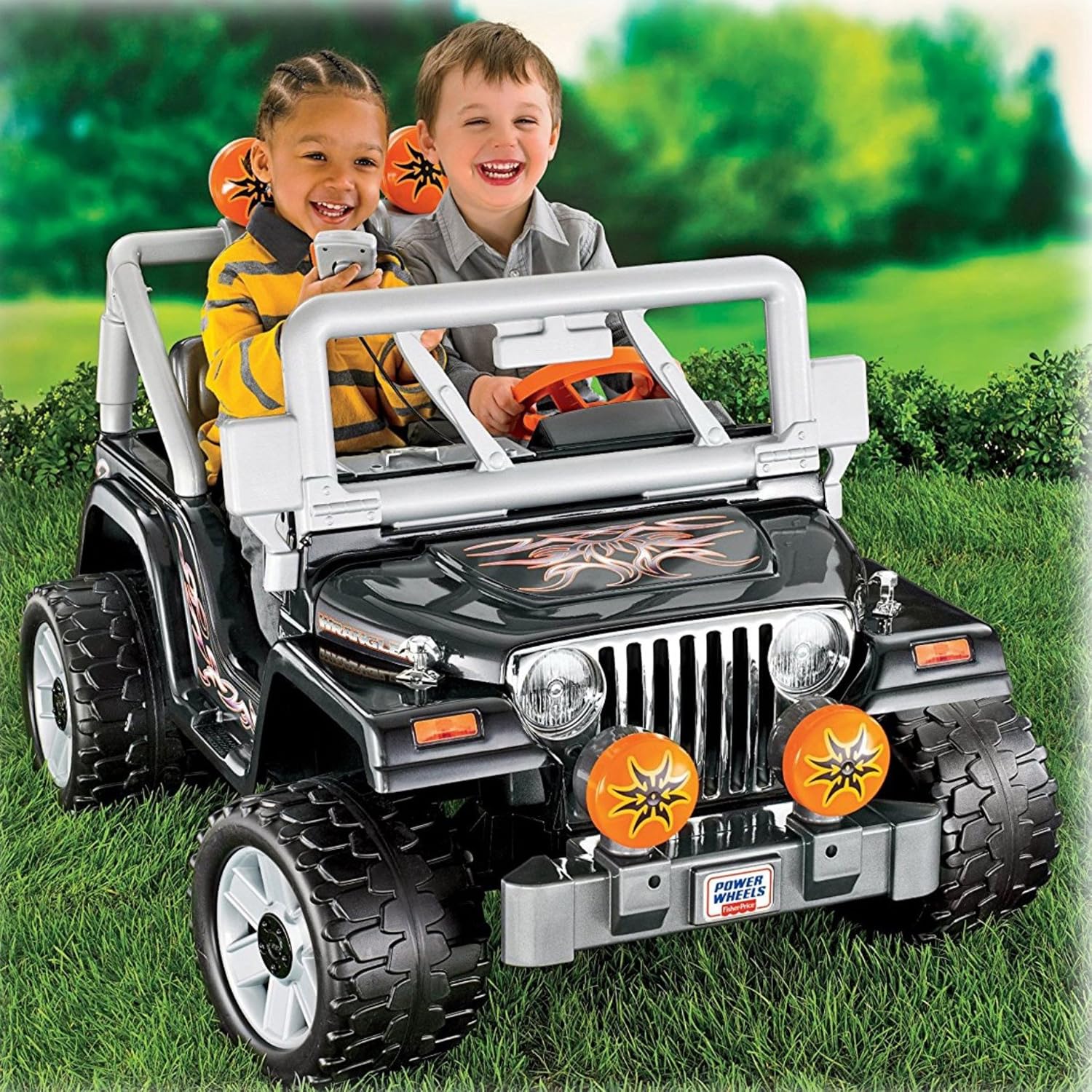 Two children riding in the Power Wheels Tough Talking Jeep Wrangler