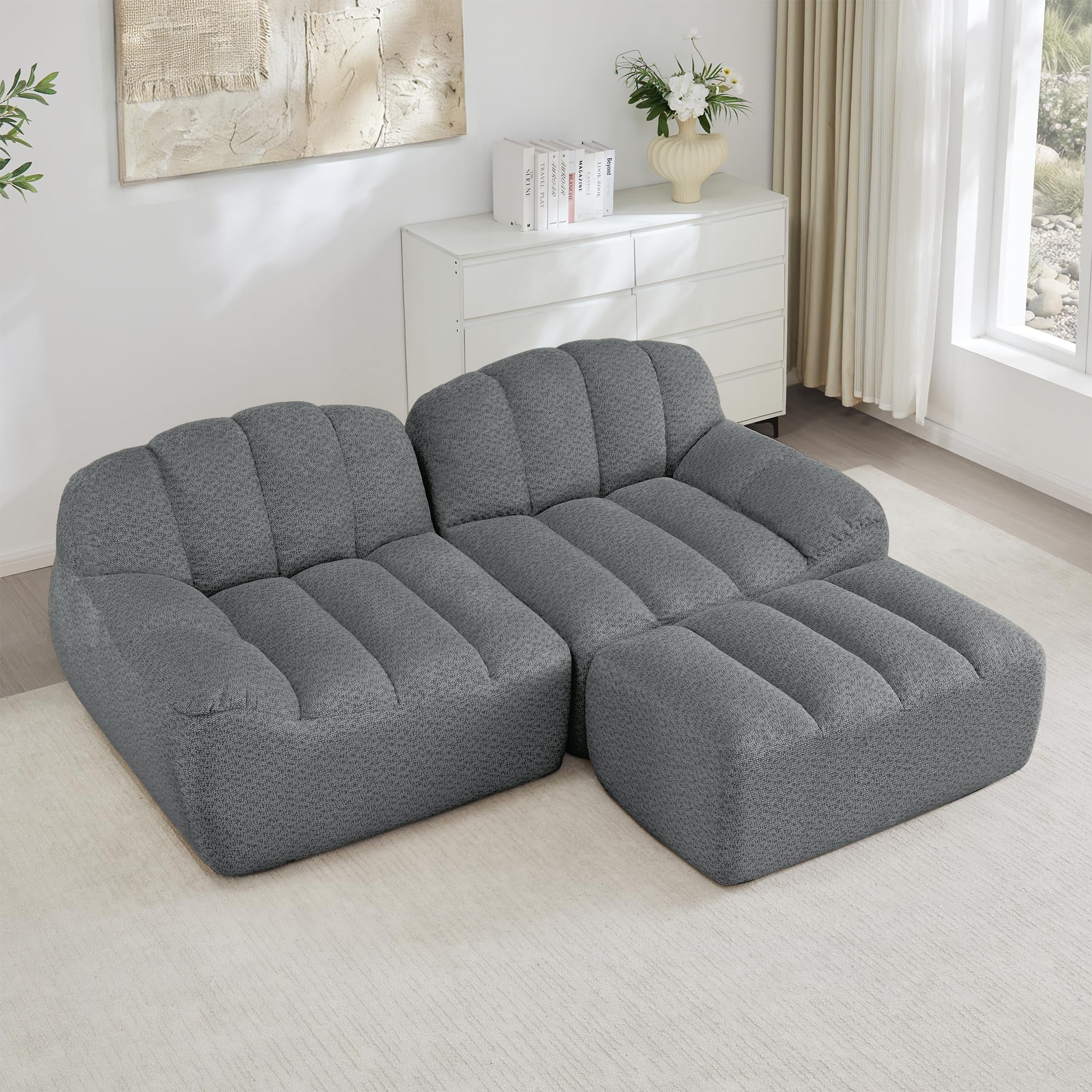 Sofá esquinero en forma de L de concha color gris tapizado con asiento profundo
