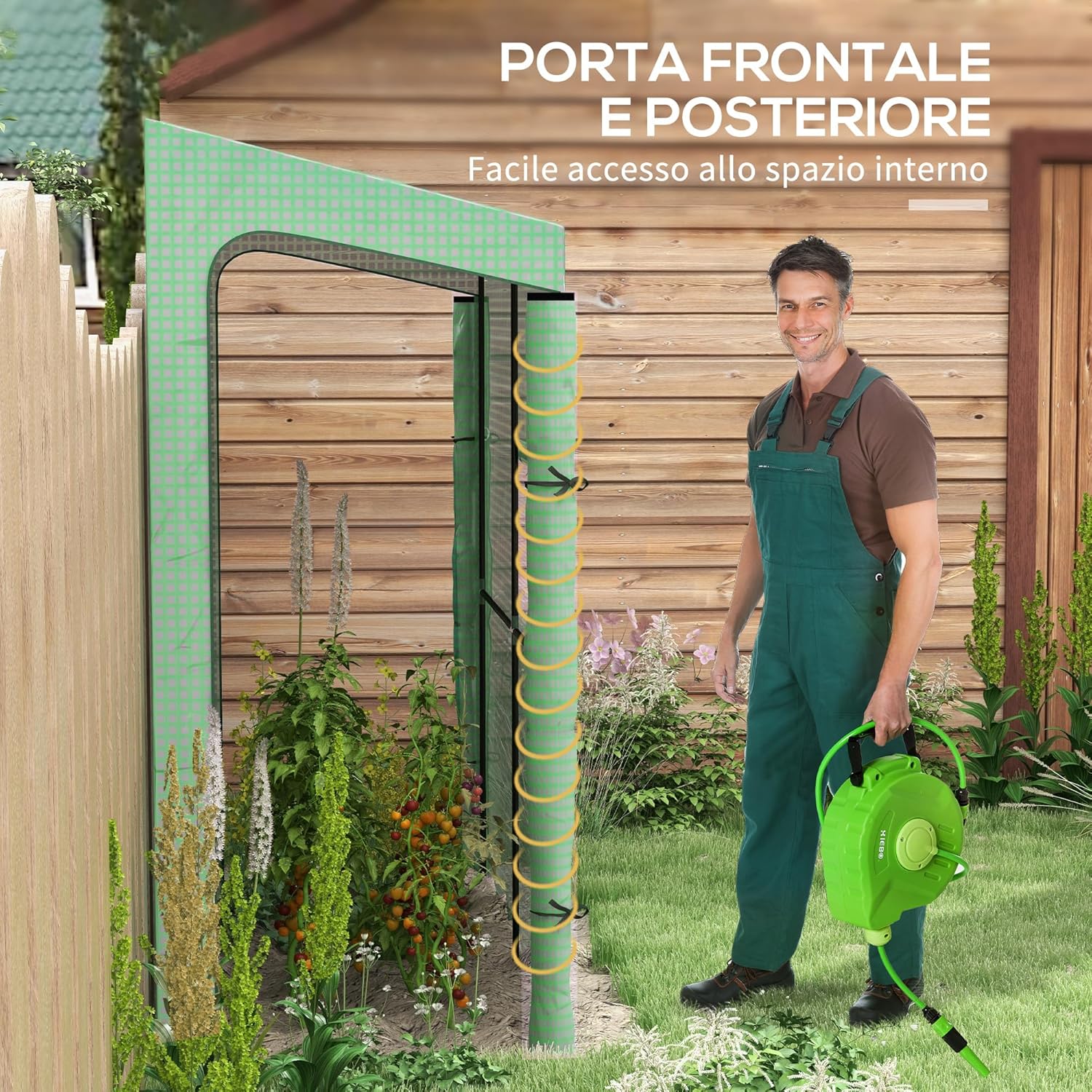 A person standing outside the greenhouse with one roll-up door open, showing easy access to the interior.