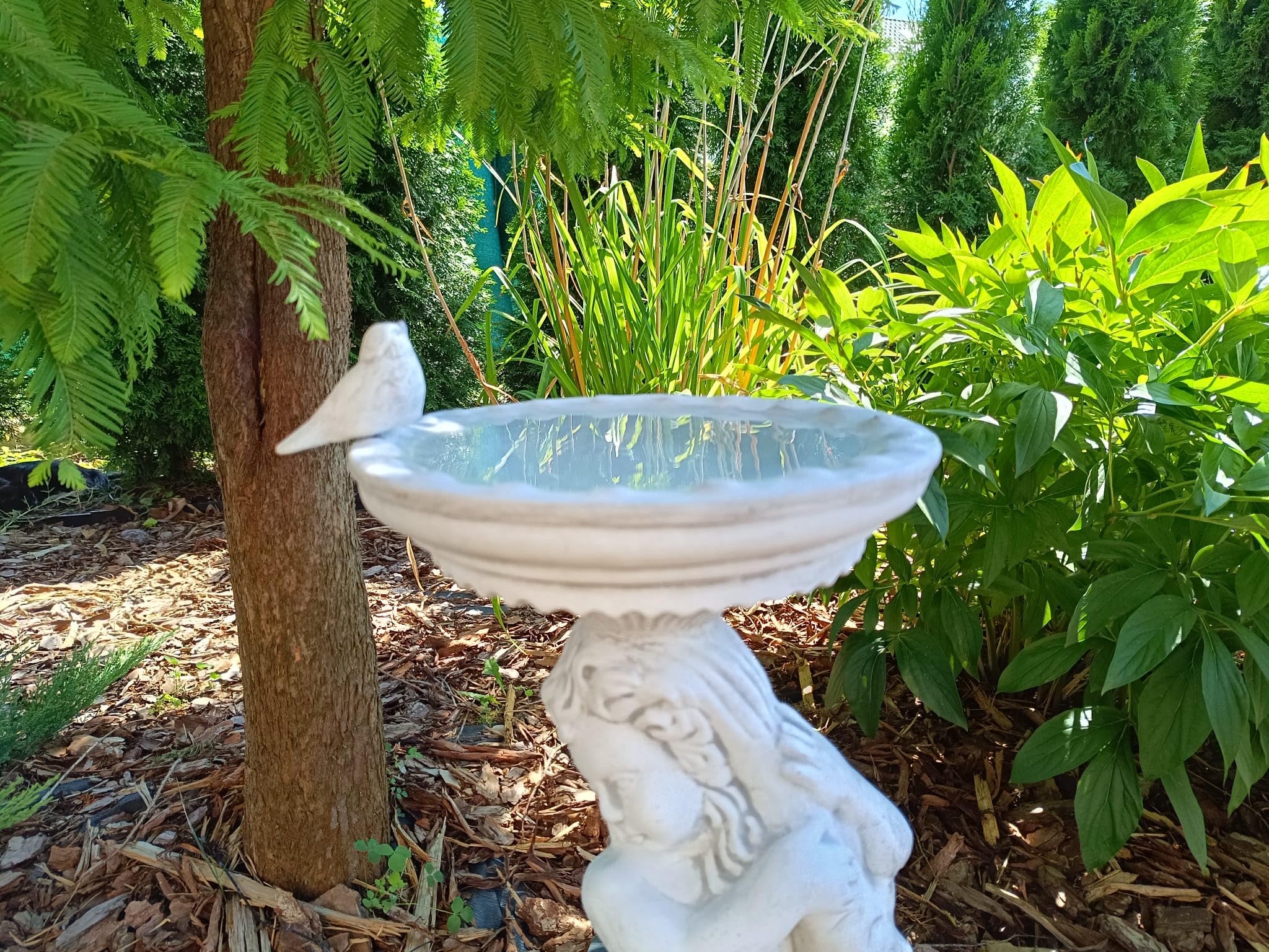 Bain d'oiseaux au design antique en forme de garçon tenant un poisson, fabriqué en pierre coulée