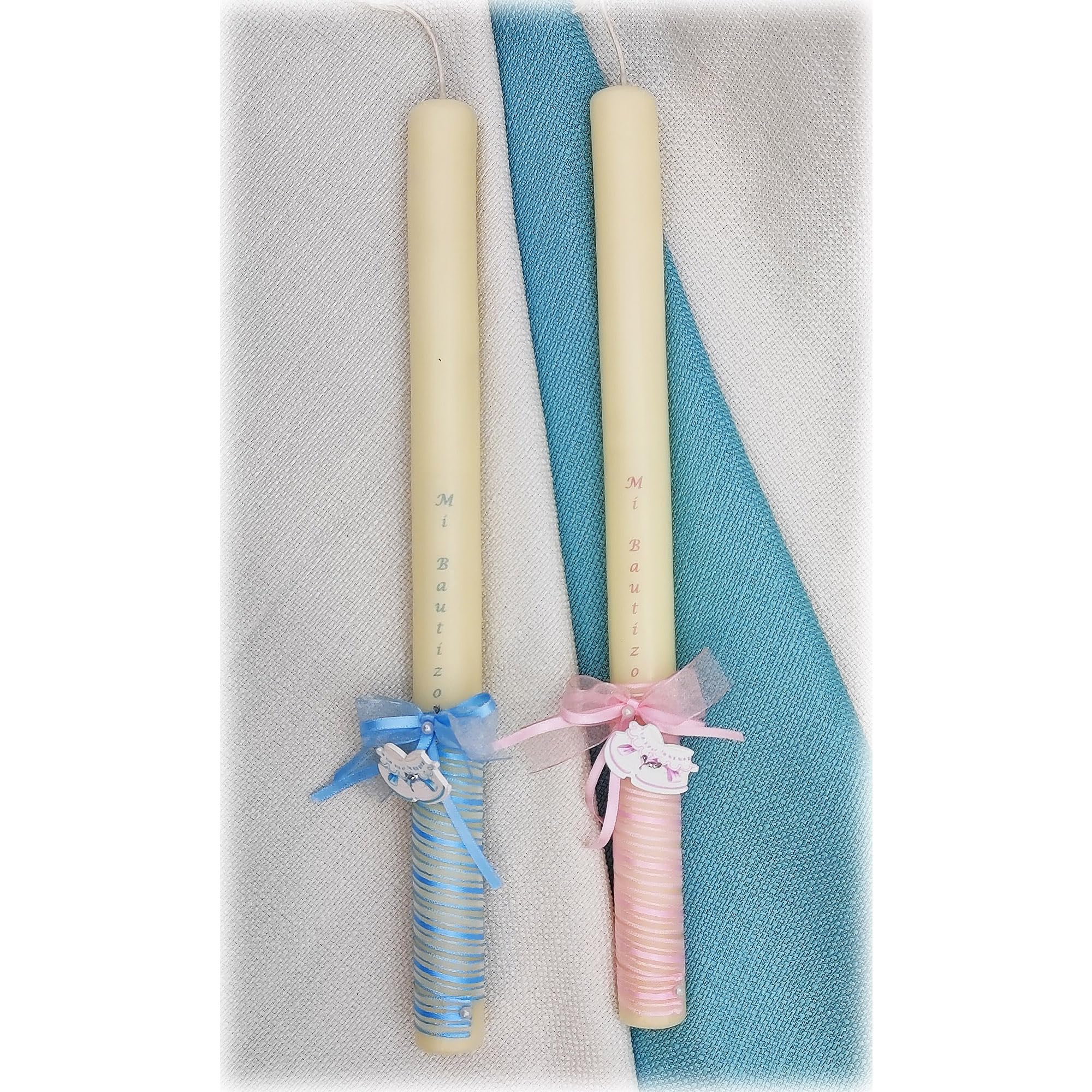 Vela de bautizo 32 zapatitos de bebé (30 x 2 cm) decorada con una cinta en espiral, un lacito con dos perlas, y un adorno de zapatitos de bebé en rosa o azul. Personalización impresa en la cera