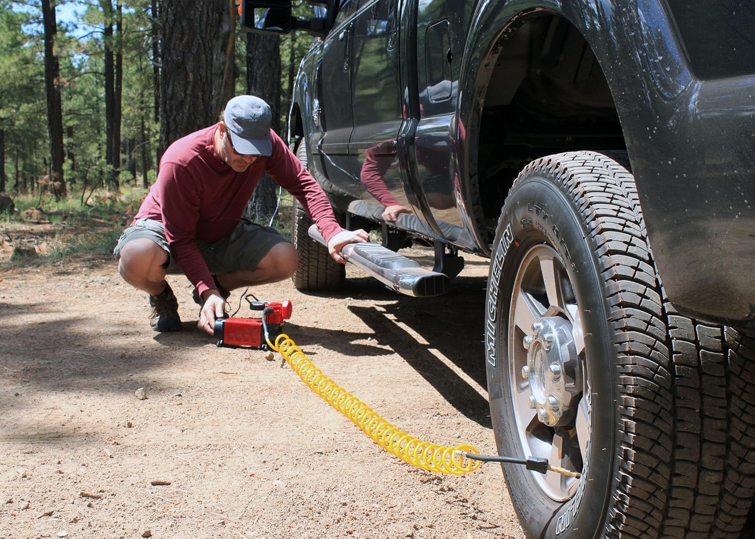 Close-up of red and black alligator clips connected to a vehicle battery terminals.