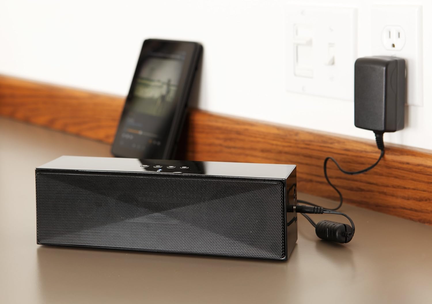 Amazon Basics Large Portable Bluetooth Speaker connected to a wall outlet for charging