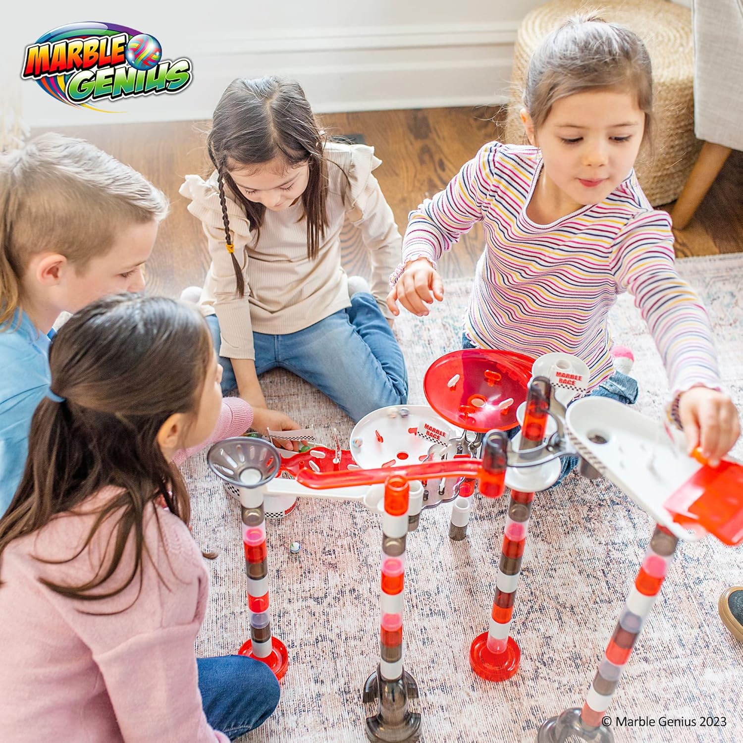 Two children looking at a tablet displaying a complex marble run design within the Marble Genius app, with App Store and Google Play logos below.