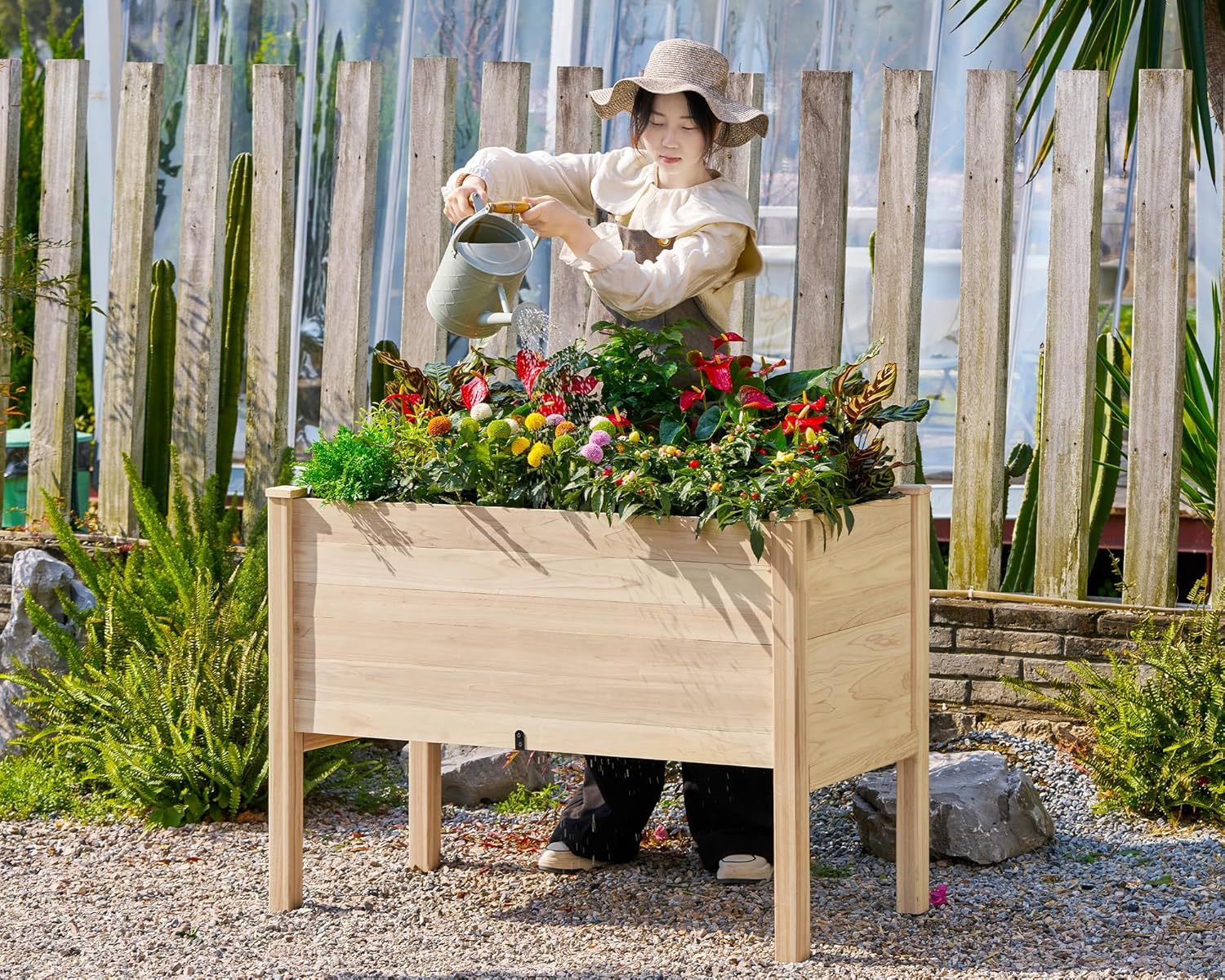 Person watering plants in the assembled raised garden bed
