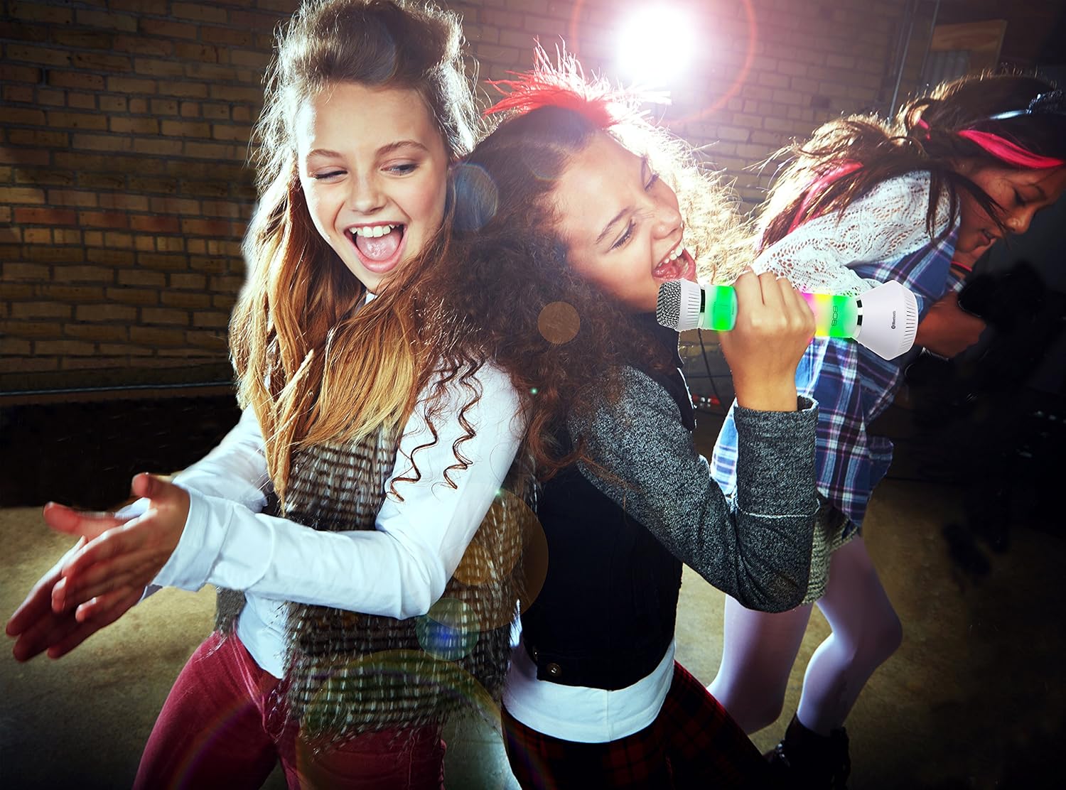 Two girls singing into 808 Singsation Karaoke Microphones with colorful lights