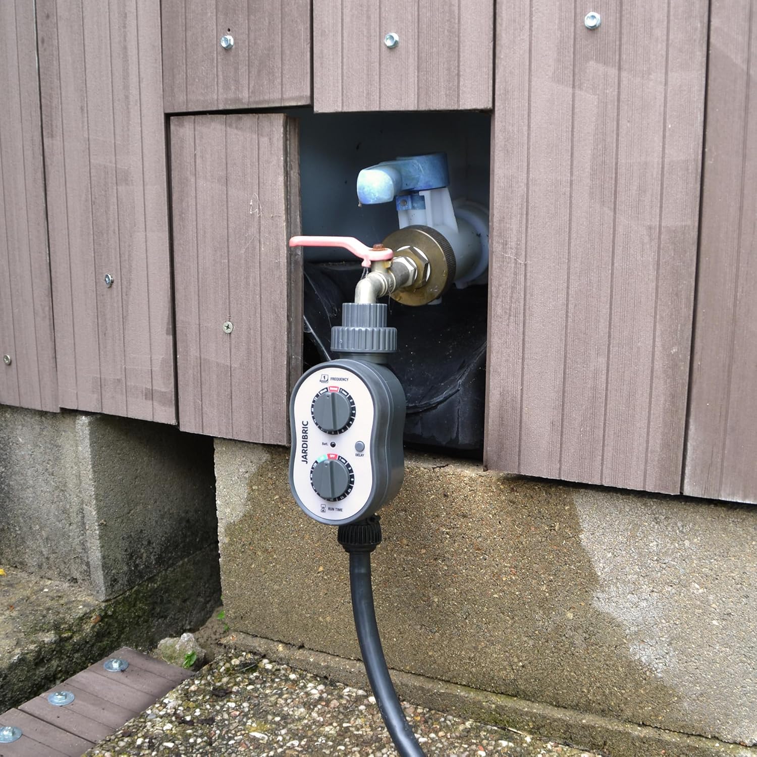 Jardibric PNR16 Irrigation Programmer installed and connected to an outdoor faucet and hose.