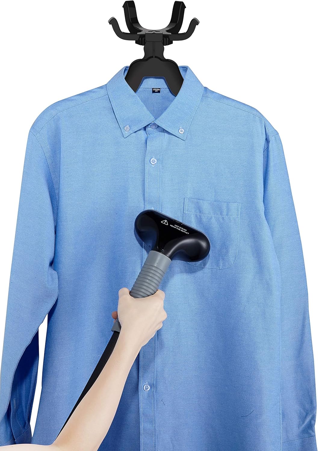A hand holding the steamer nozzle against a blue shirt on the hanger, illustrating the steaming process.