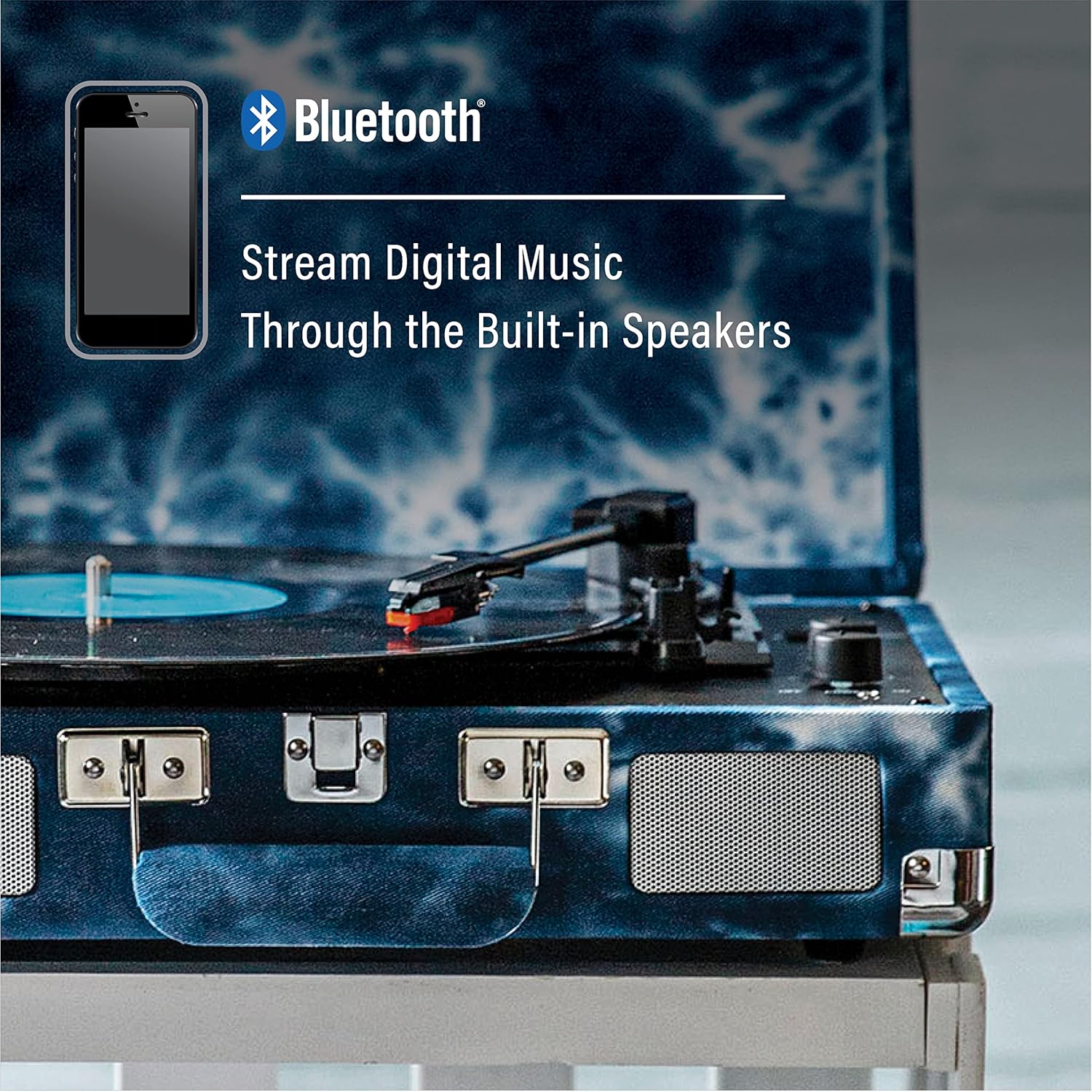 Smartphone displaying Bluetooth icon next to the Crosley Cruiser Plus turntable, indicating digital music streaming to built-in speakers.