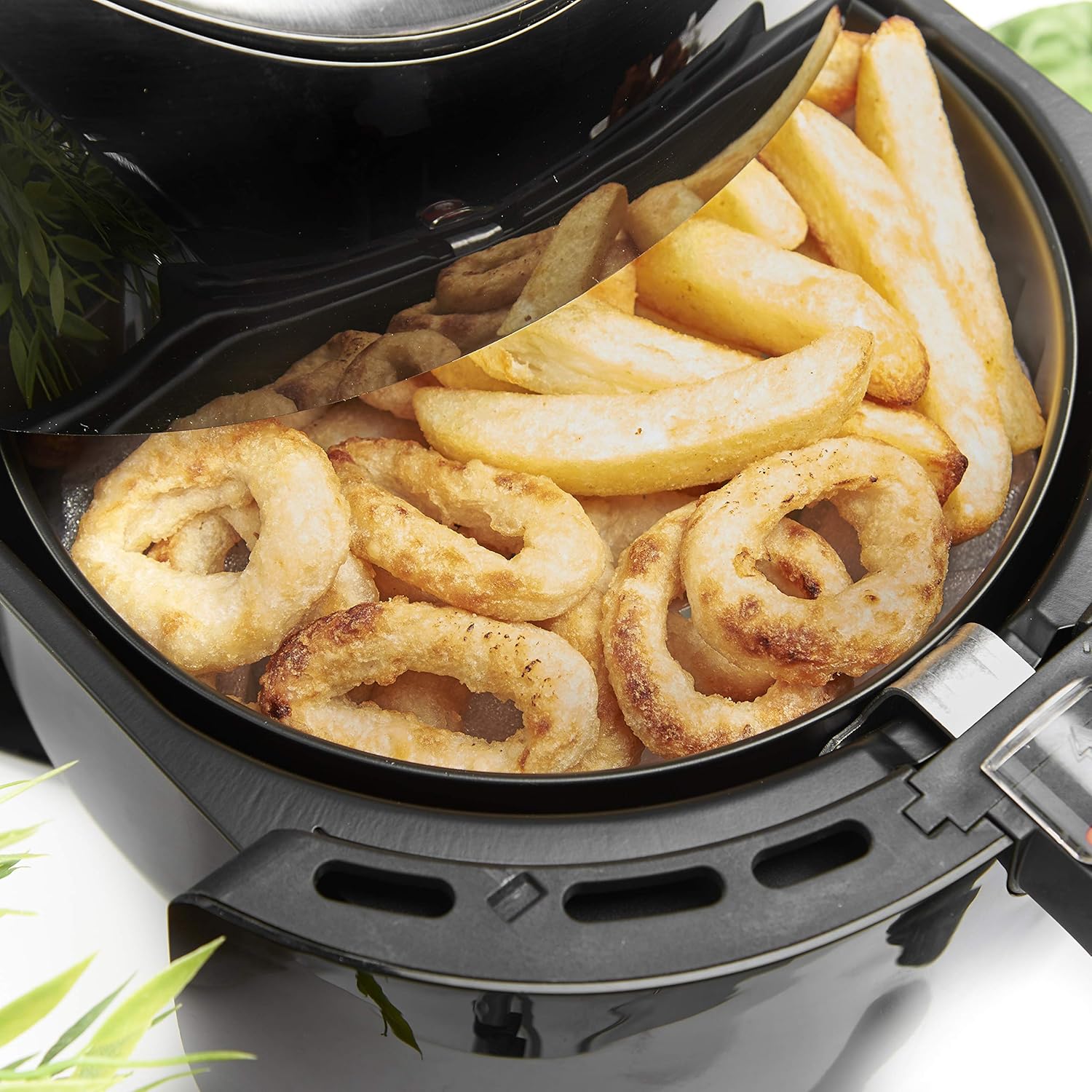 Fries and onion rings in air fryer basket